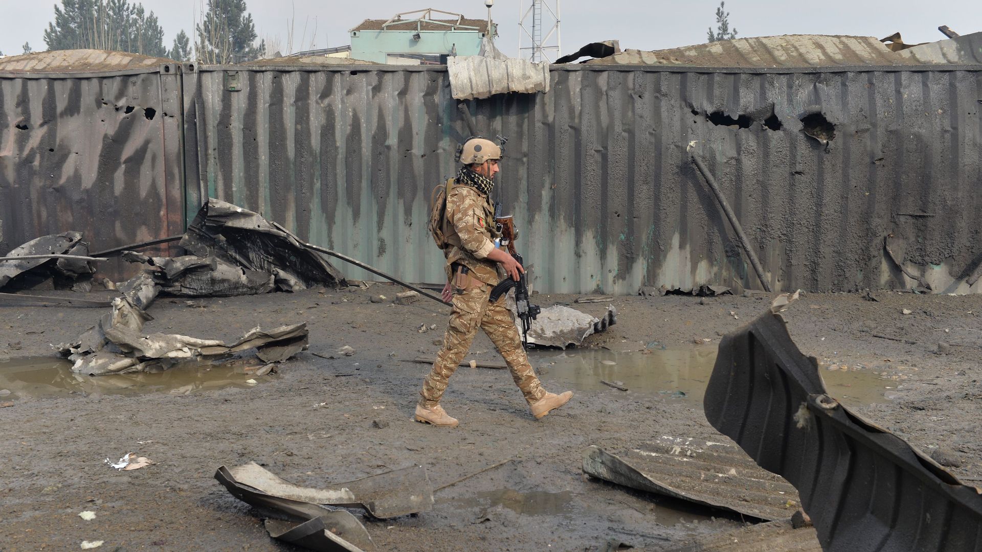 A member of the Afghan security forces walks at the site of a suicide bomb attack outside a British security firm's compound in Kabul, a day after the blast on November 29, 2018. 