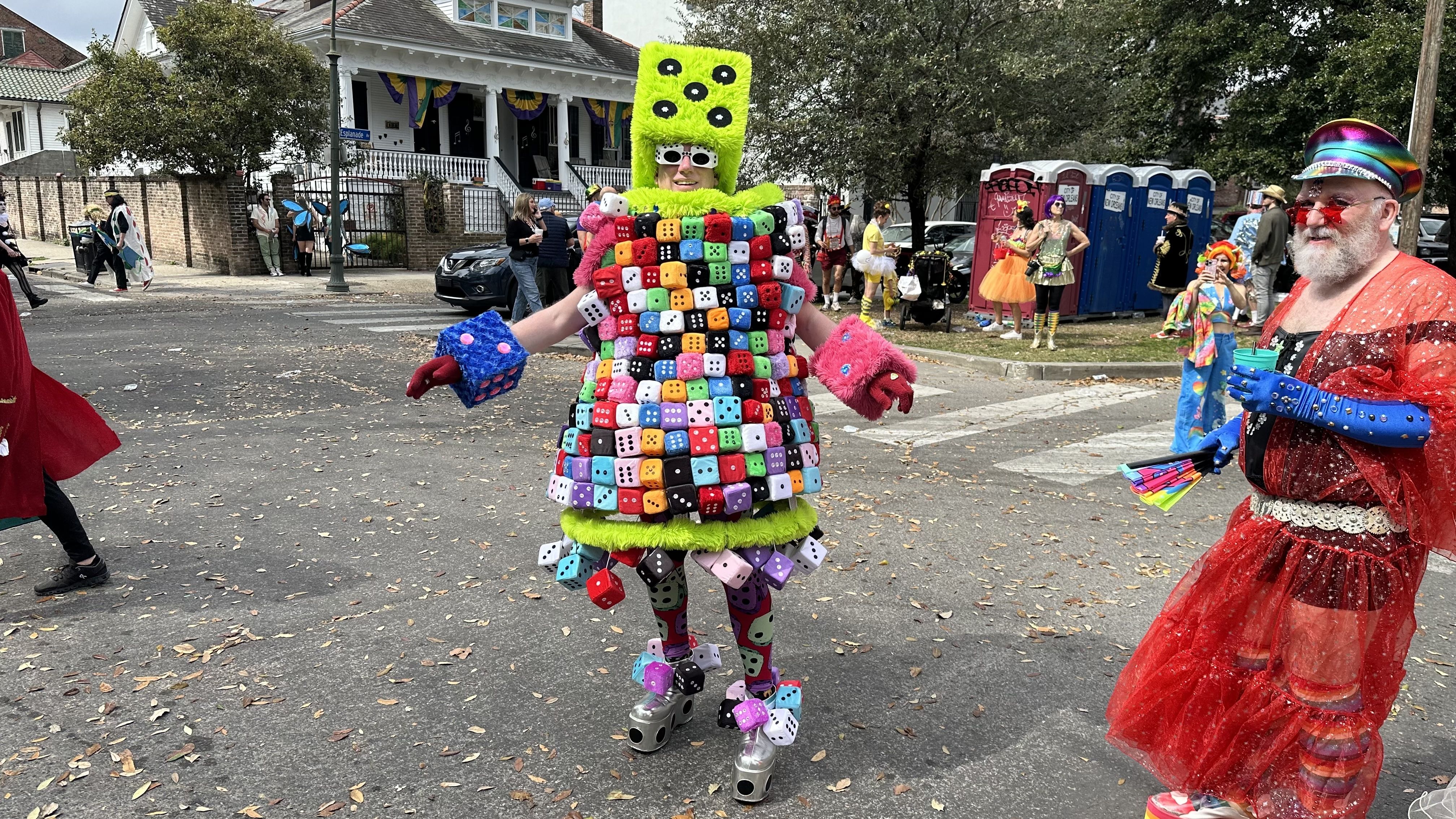 A person dressed in costume covered in fuzzy colorful dice.