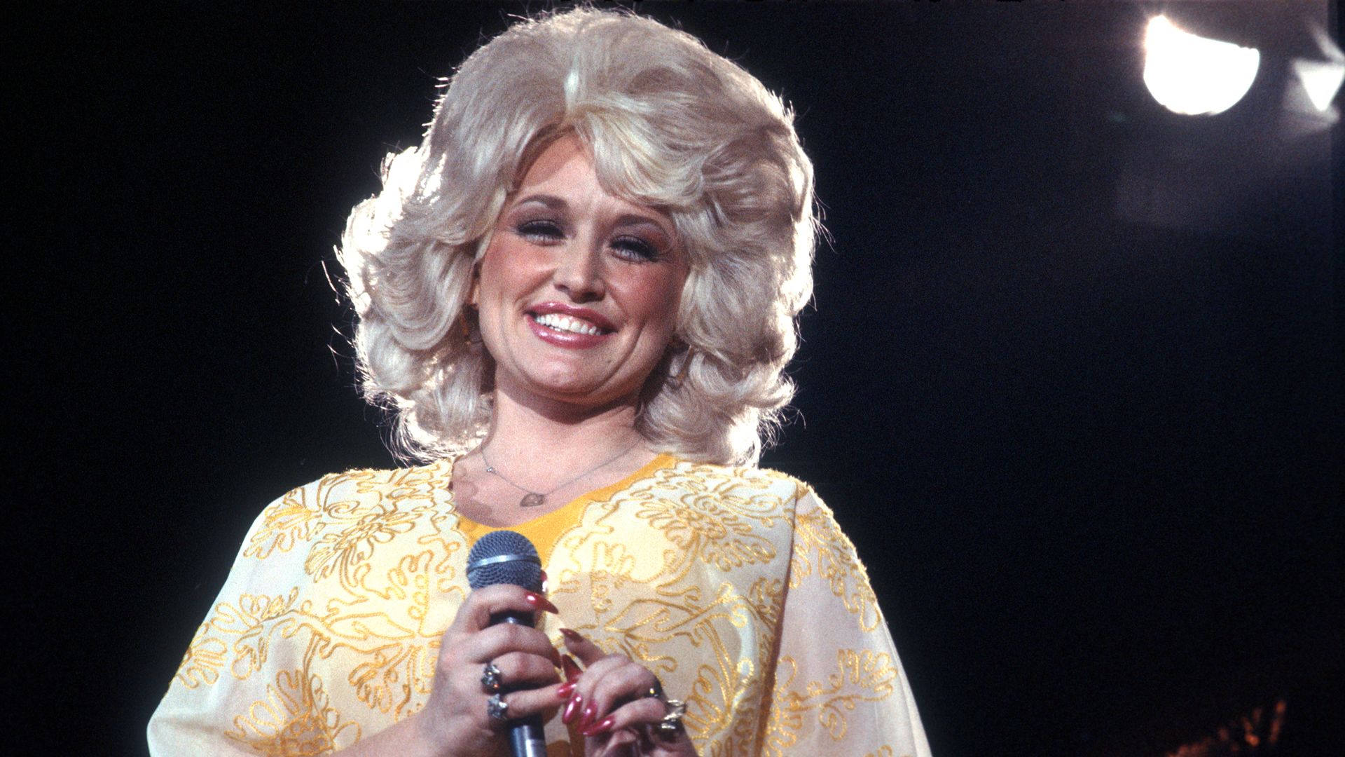 Parton performing on stage.
