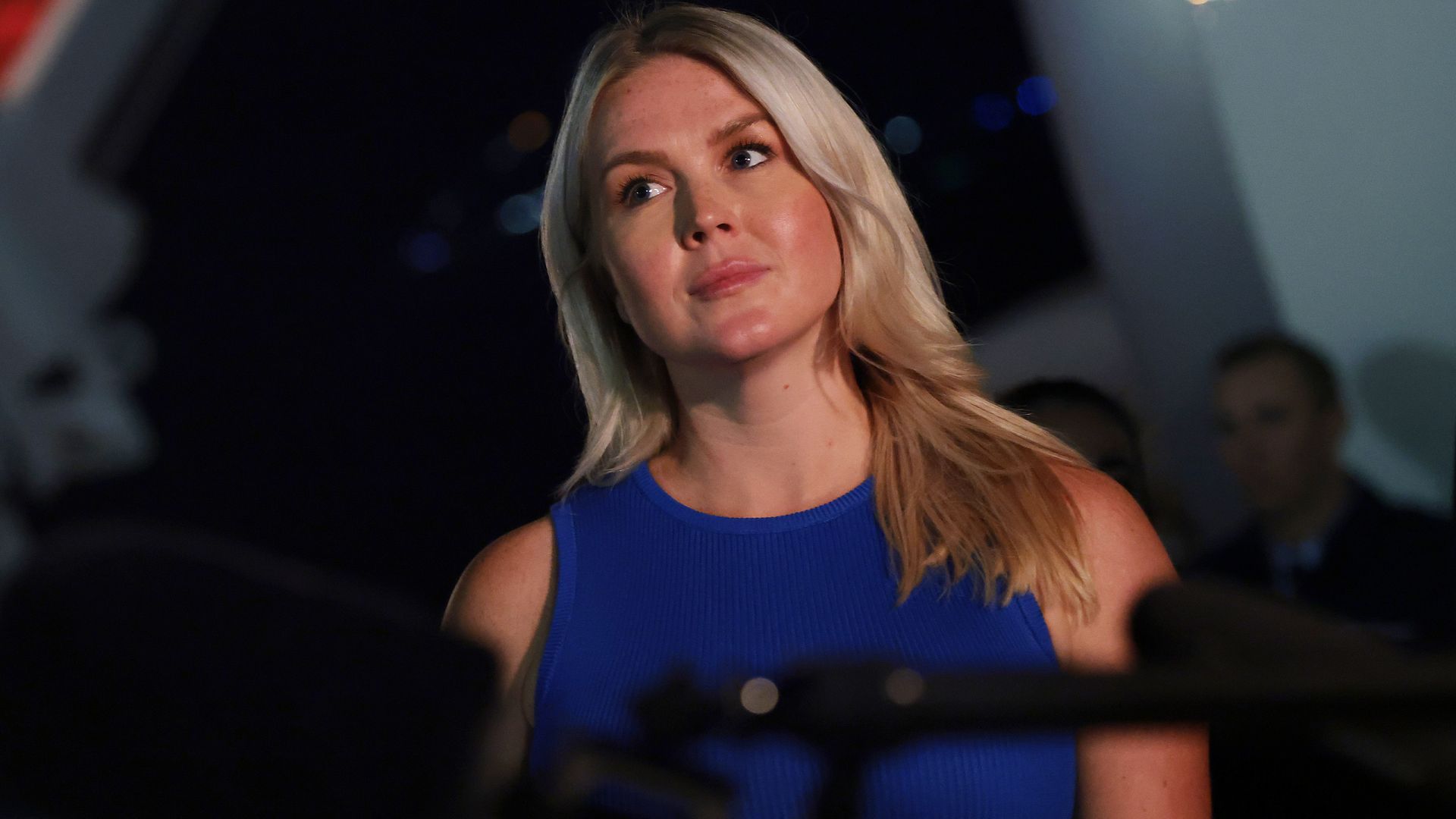 President Trump speaks to reporters on the tarmac at Joint Base Andrews as White House press secretary Karoline Leavitt stands nearby.