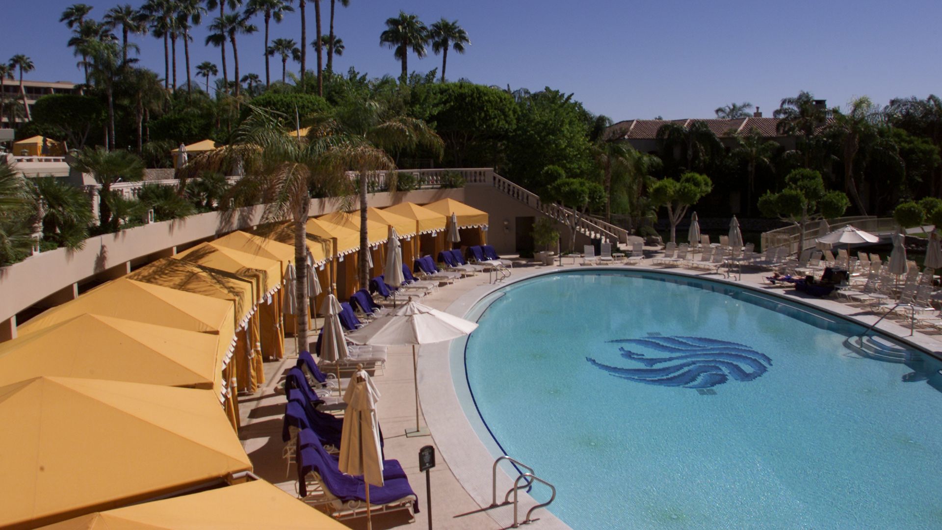 A resort pool surrounded by cabanas. 