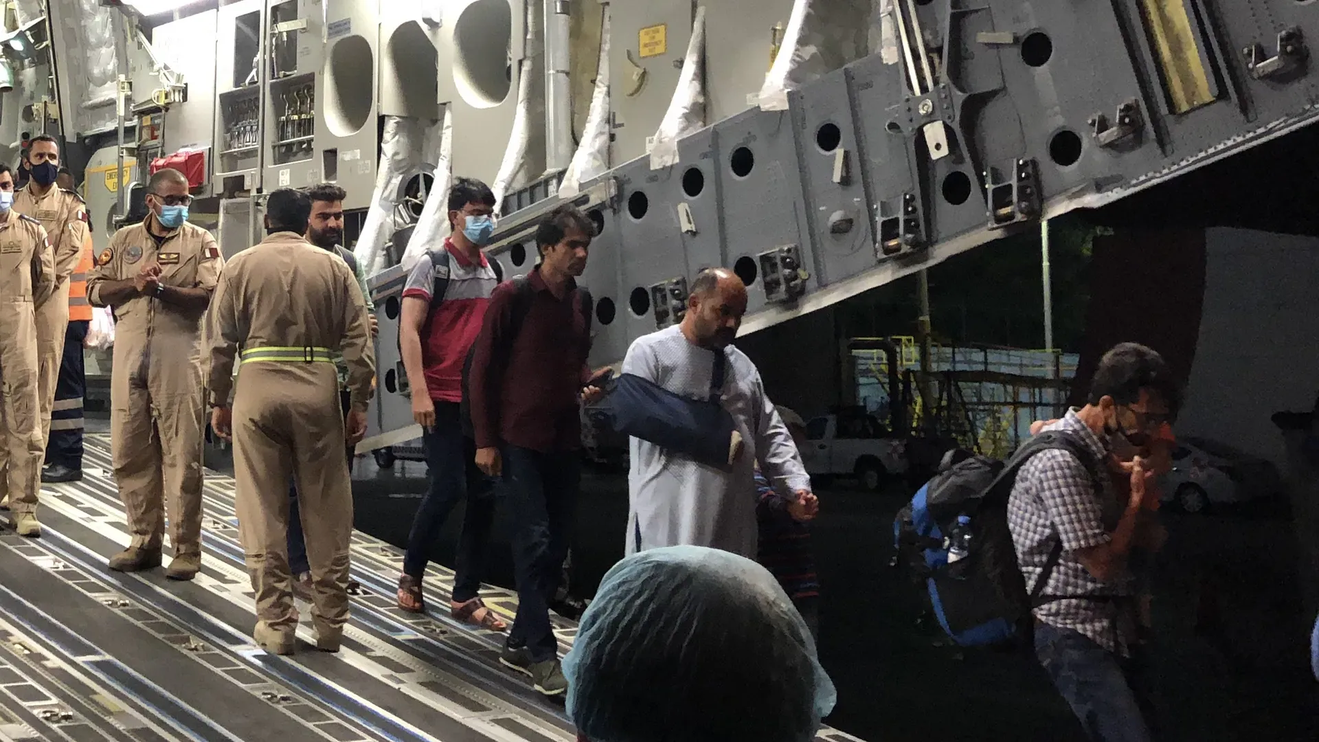 Members of The New York Times' group deplaning from a military plane provided by Qatar in Mexico City.