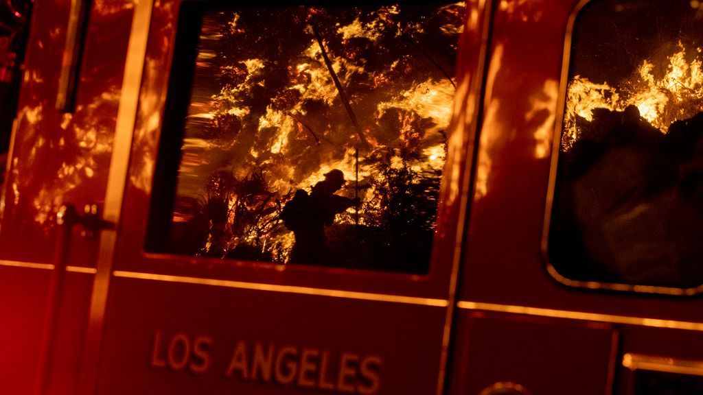 Image of the raging fires are reflected on windowpane of firetruck in Los Angeles
