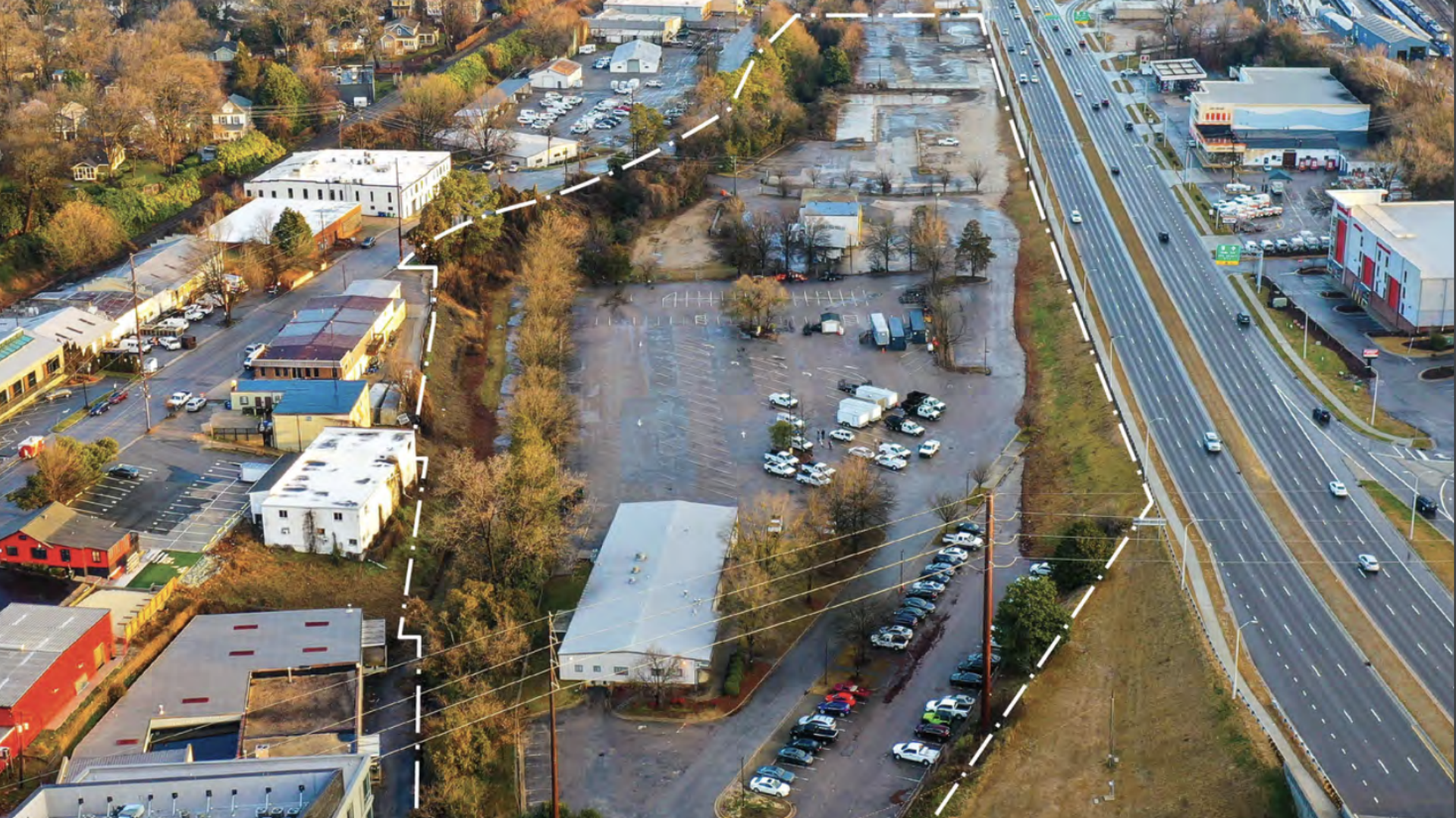 A parking lot with cars surrounded by roads.