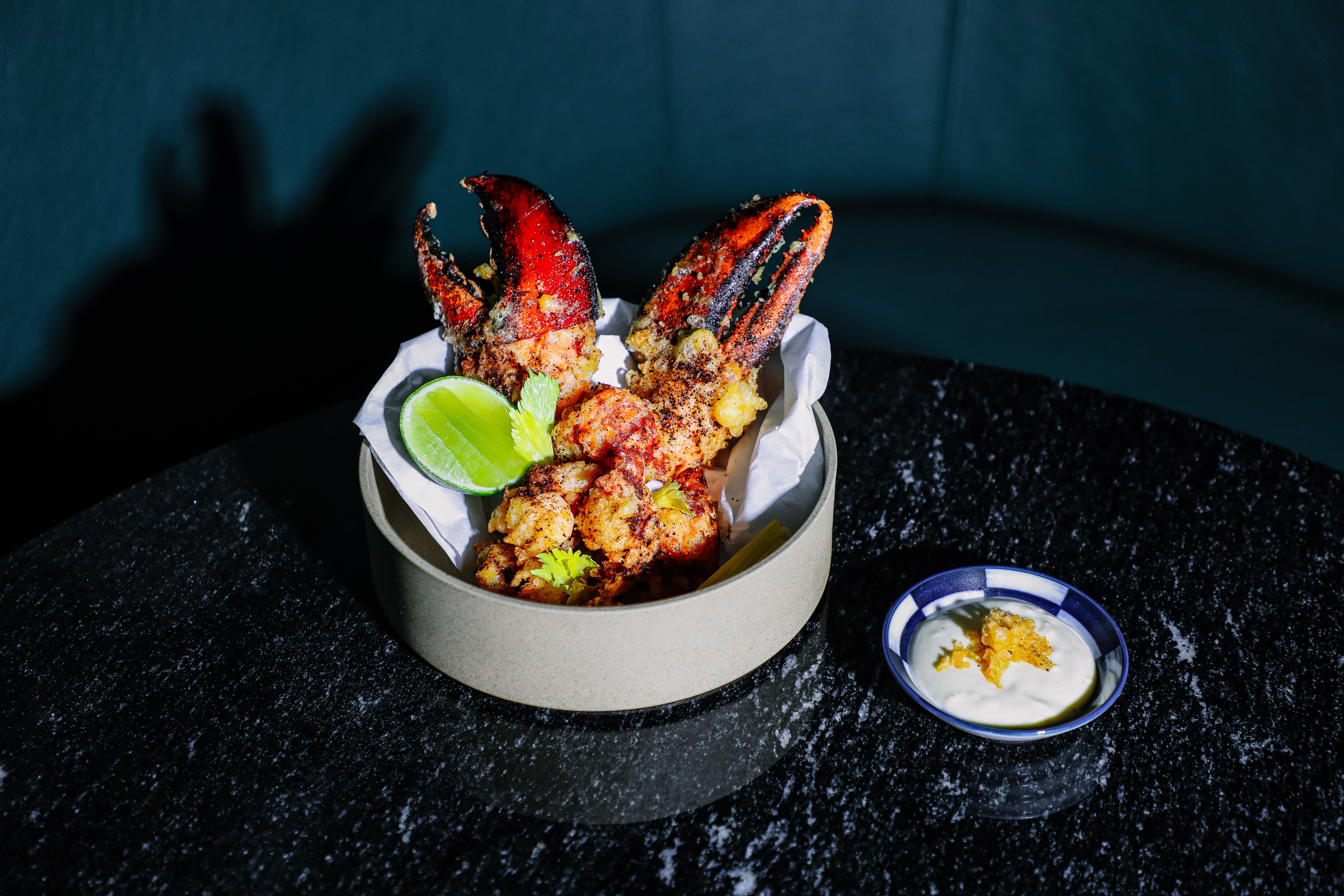 Two fried lobster claws and meat in a bowl