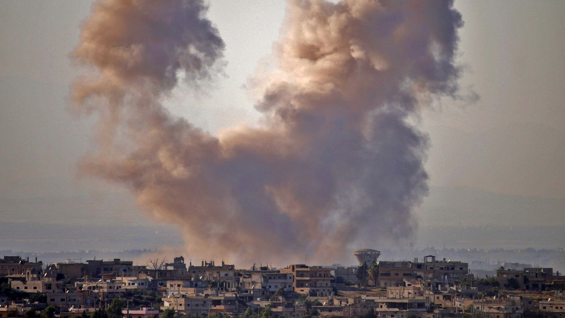 smoke rising over town of Daraa, Syria, after an airstrike