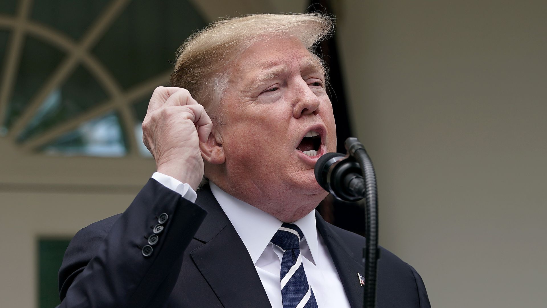 President Donald Trump makes a gesture during a speech.