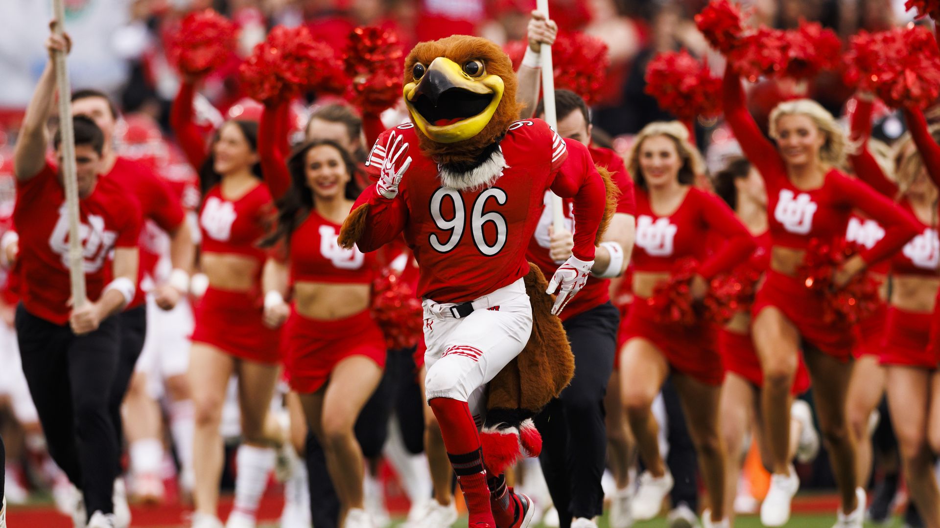 A mascot in a red 96 jersey runs onto the field before a football game