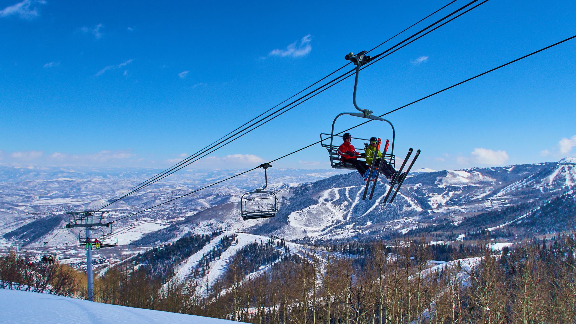Skiers are sitting in a chair lift with panoramic view of the Wasatch Range in the Rocky Mountains on March 02, 2015 in Park City, Utah, United States. 