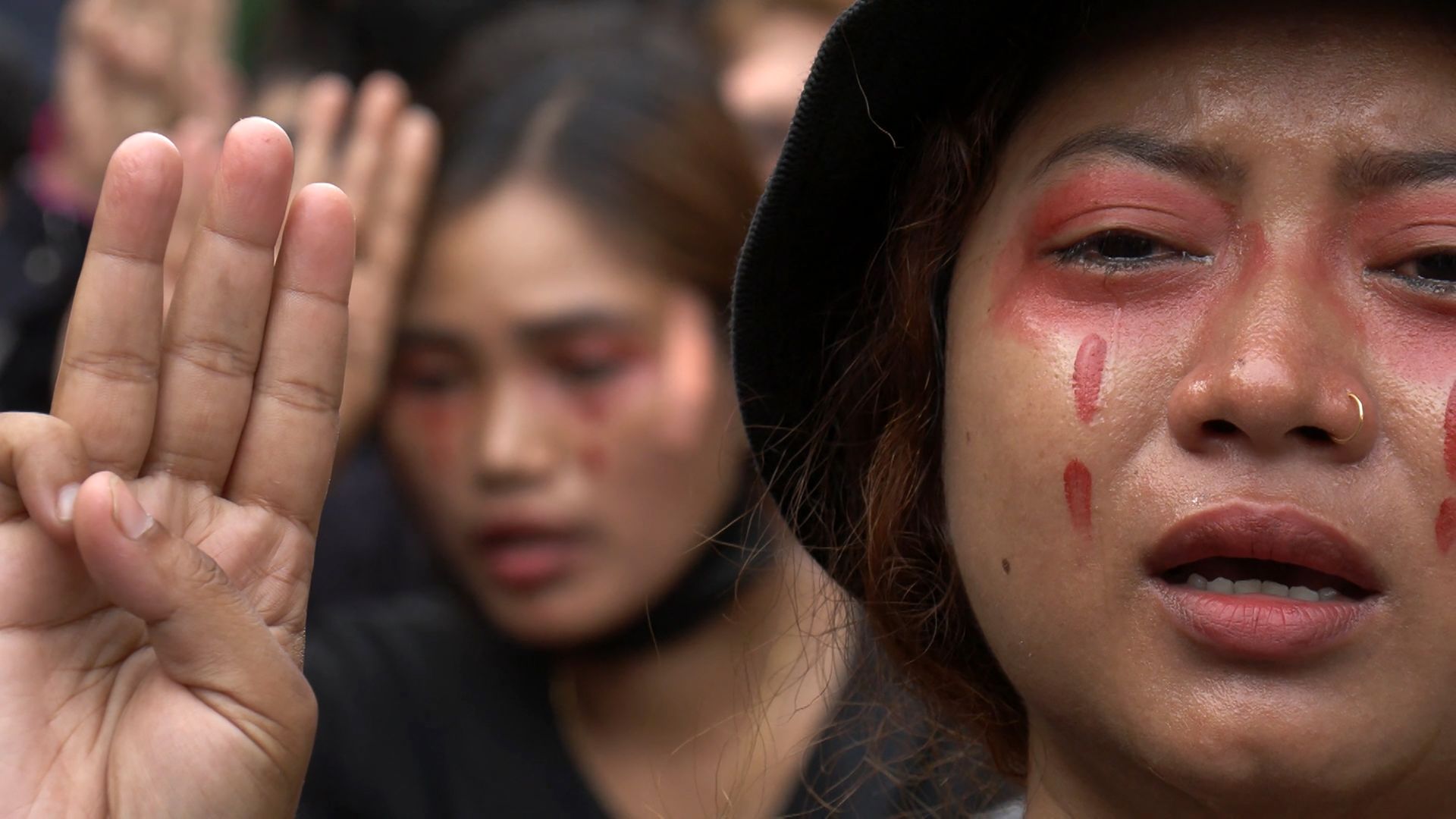 A protester, wearing red make-up to simulate tears of blood, crying while making the three-finger salute during a demonstration against the military coup in Yangon's Hlaing township.