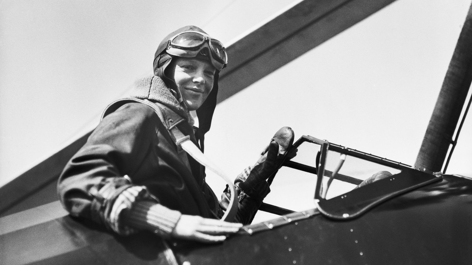 Black and white photo of Amelia Earhart in an airplane