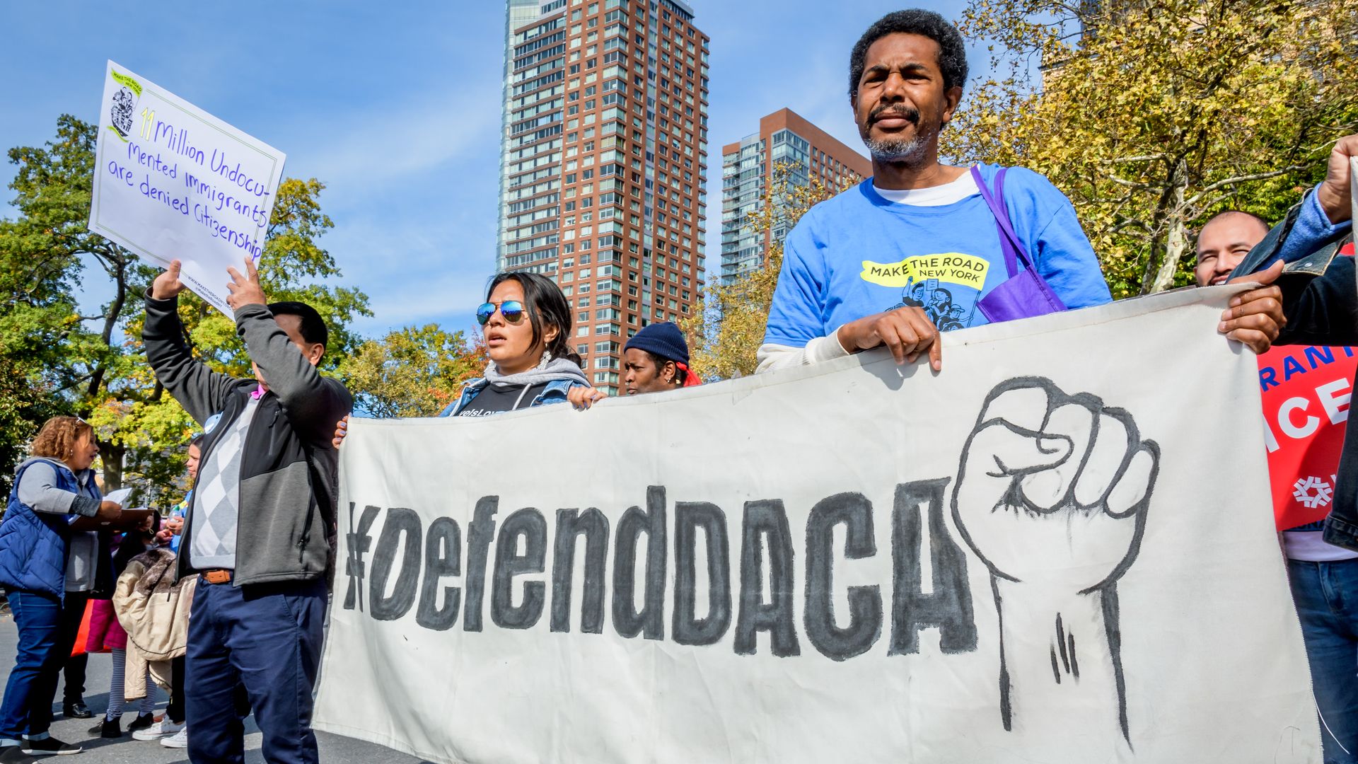 Protestors hold signs saying "Defend DACA"