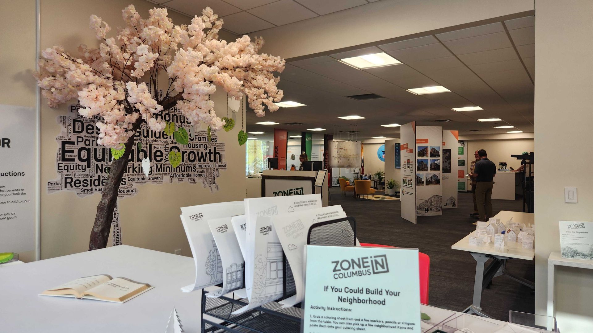 A zoning code exhibit space with two people standing in front of a large display of photos. 