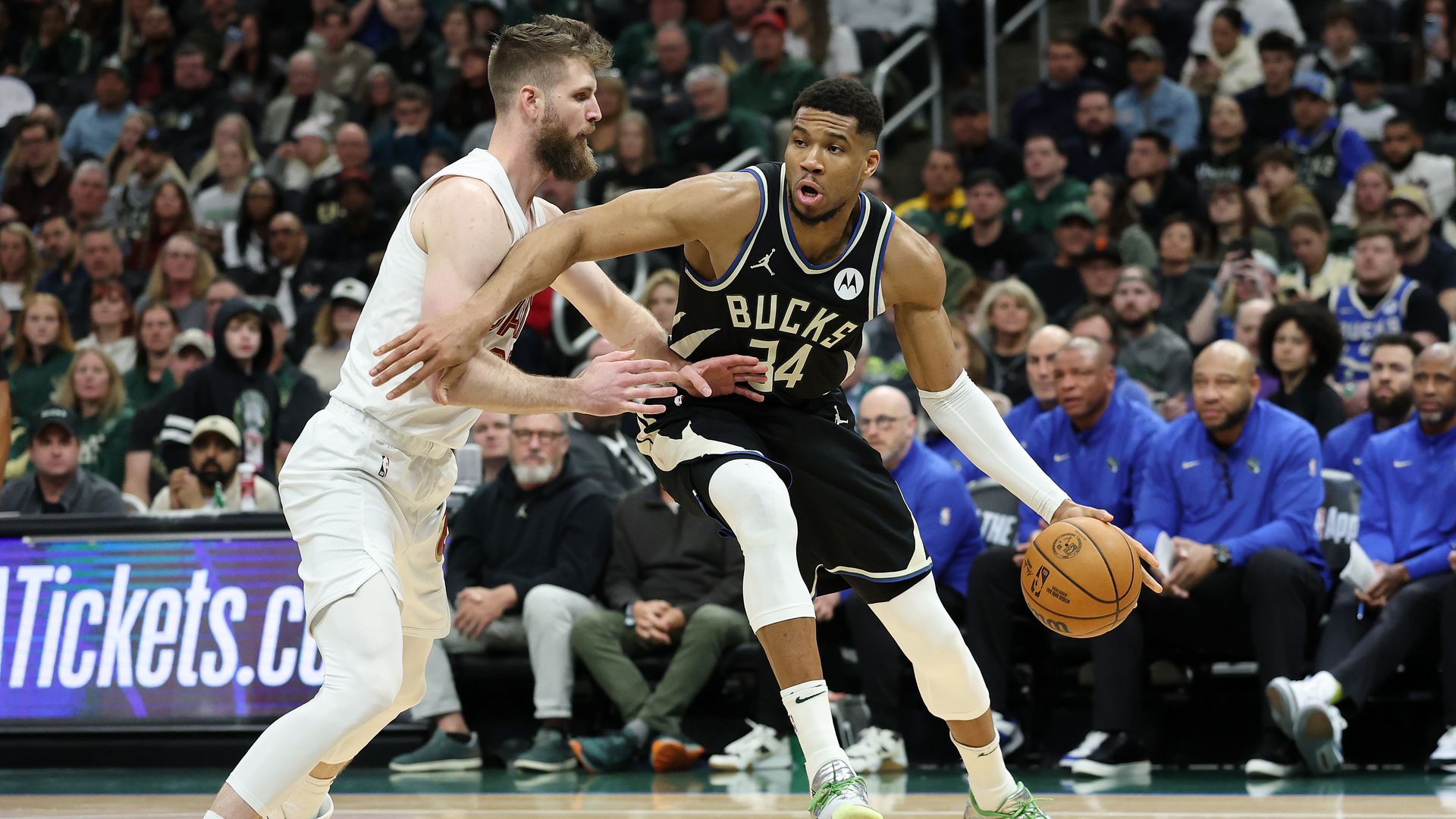 A white NBA player Dean Wade guards Giannis Antetokounmpo in black jersey
