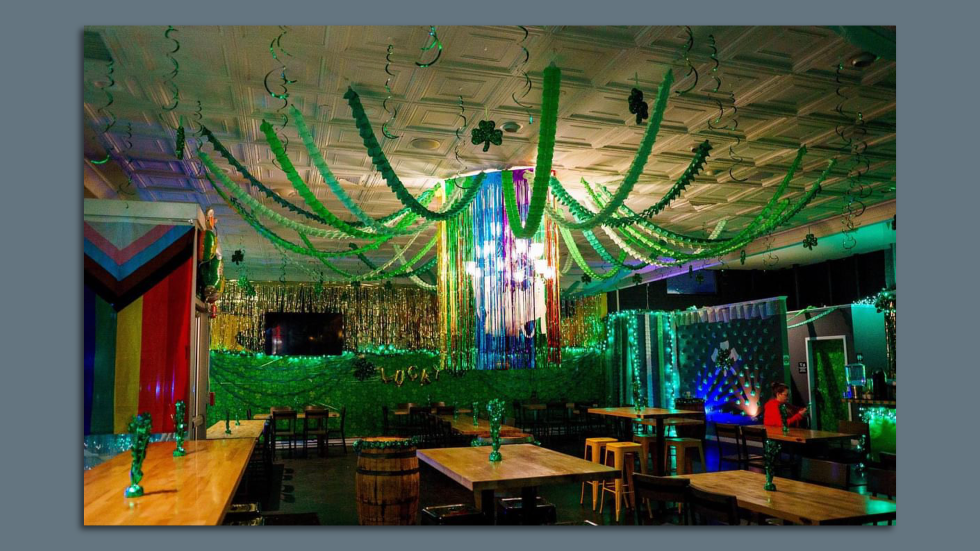A dining room covered in green streamers and lights and flags 