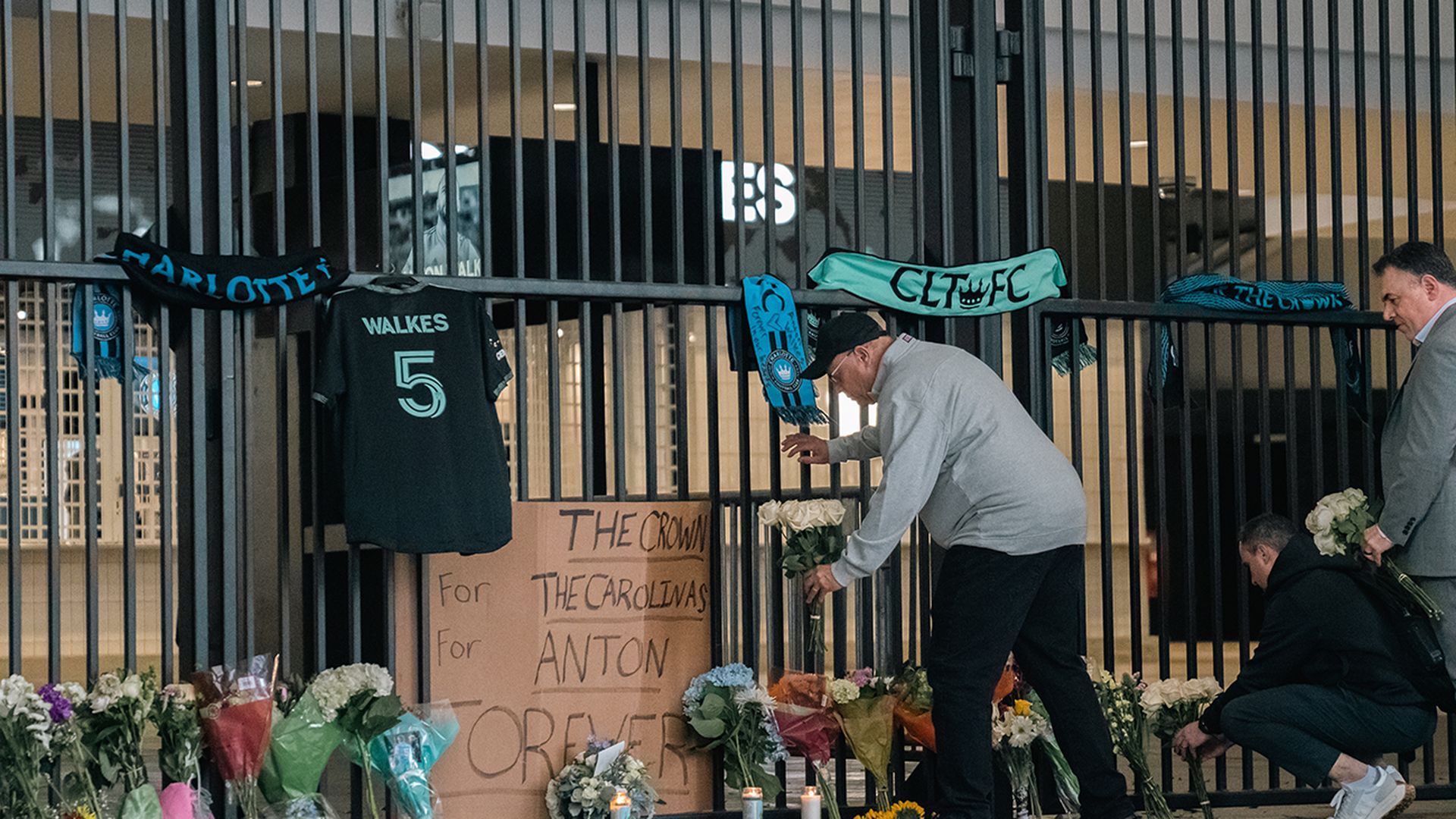 Charlotte FC Owner David Tepper places roses at a vigil outside of the stadium for defender Anton Walkes. Photo: Andy Weber/Axios