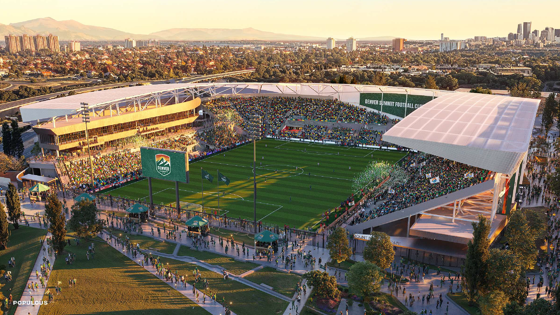 Aerial view of a large stadium with a green football field, white-roofed stands, and a colorful crowd. Denver Summit Football Club banner; city skyline and distant mountains glow in golden hour light.