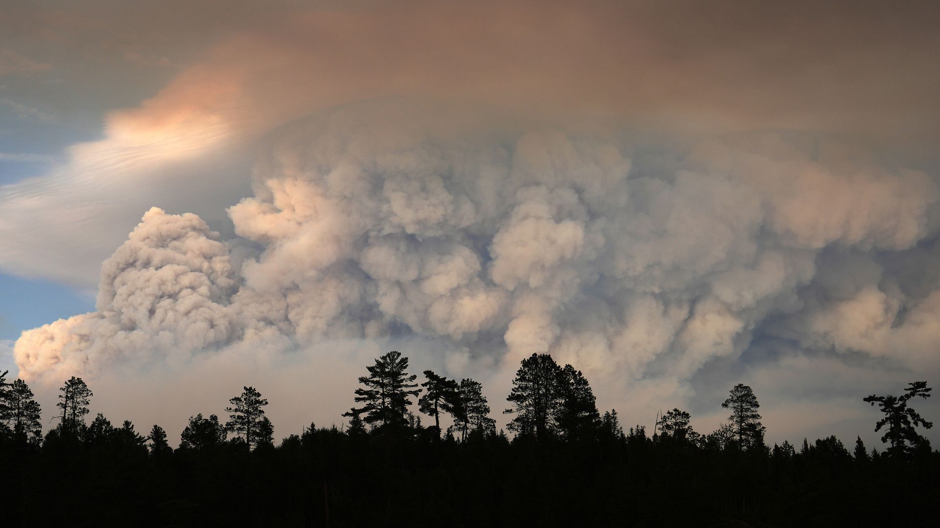 Plumes of smoke hang in the air on Moose Lake Tuesday as multiple wildfires burn in the Boundary Waters Canoe Area Wilderness.