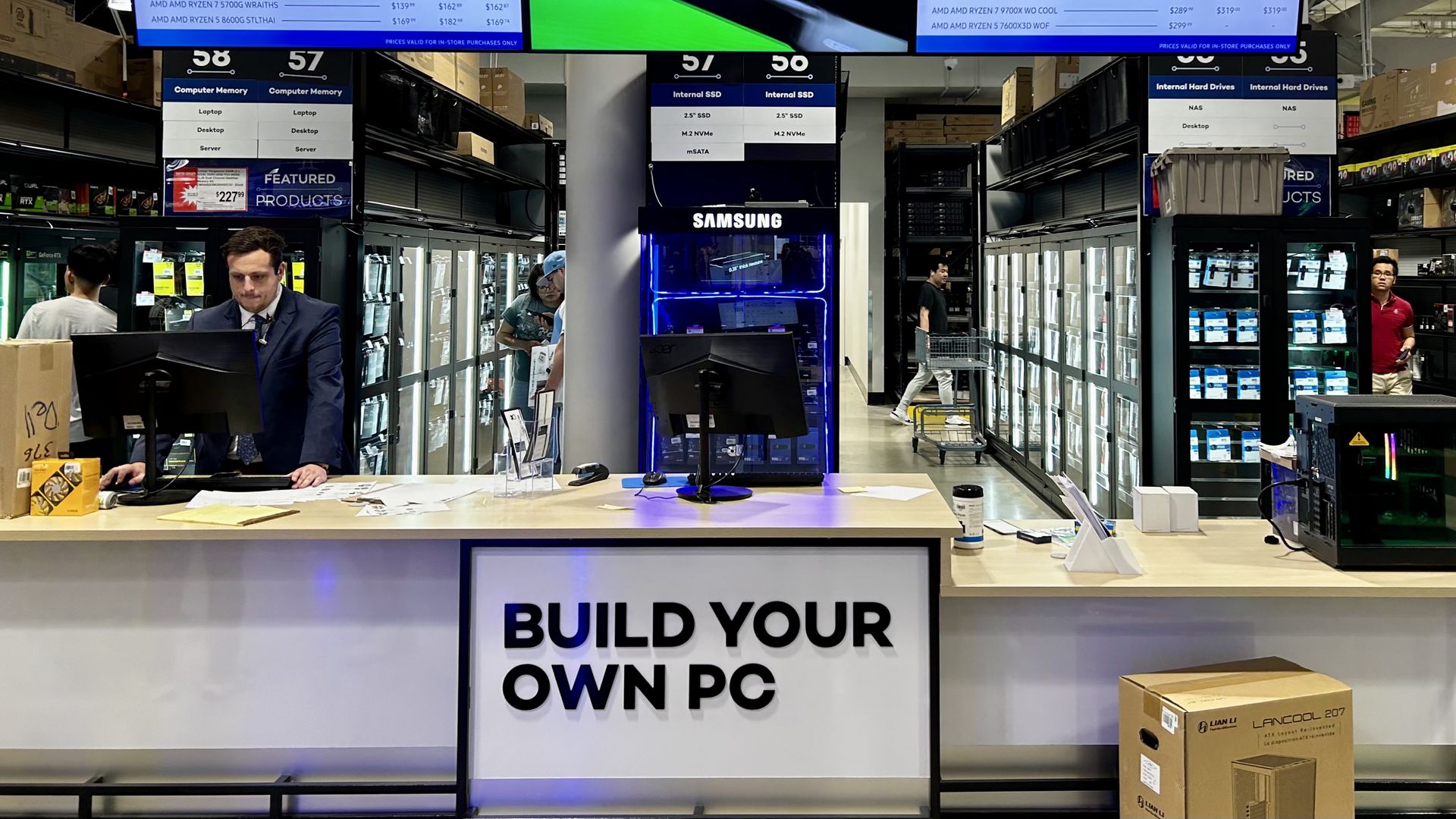Photo of aisles of technology products and a desk at the front with a sign that says "Build your own PC"