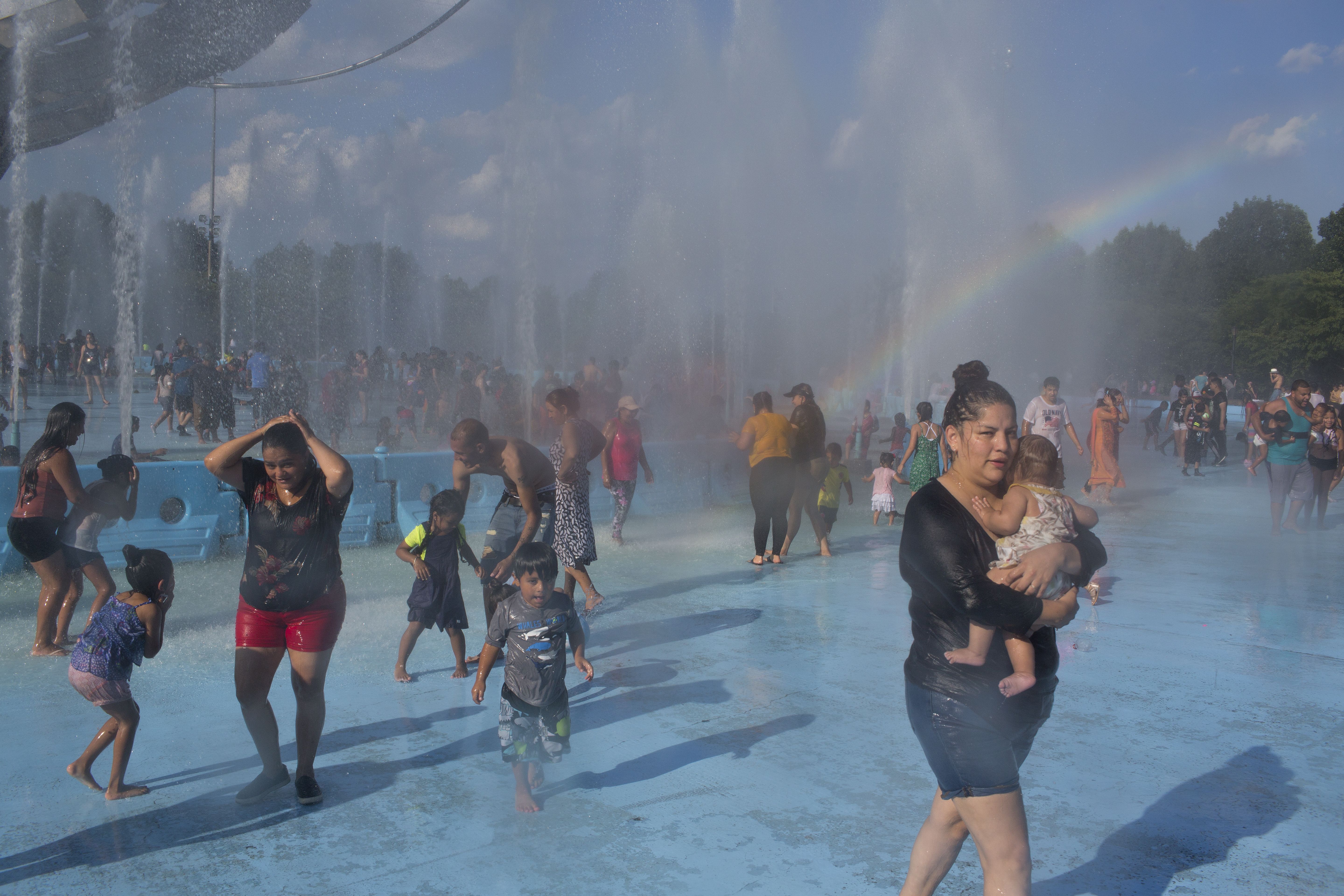 As a heat wave descends upon the city, people seek refuge from the record high temperatures at the fountains in Flushing Meadows Park on July 21, 2019 in the Queens borough of New York City