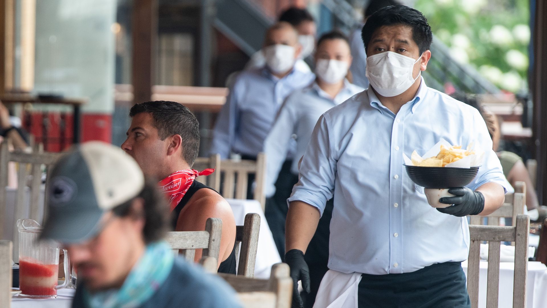 A waiter delivers food to customers at a D.C. restaurant. 