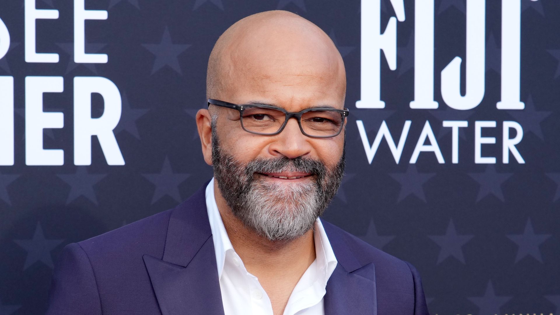 An image of the actor Jeffrey Wright, wearing a blue suit and glasses. 