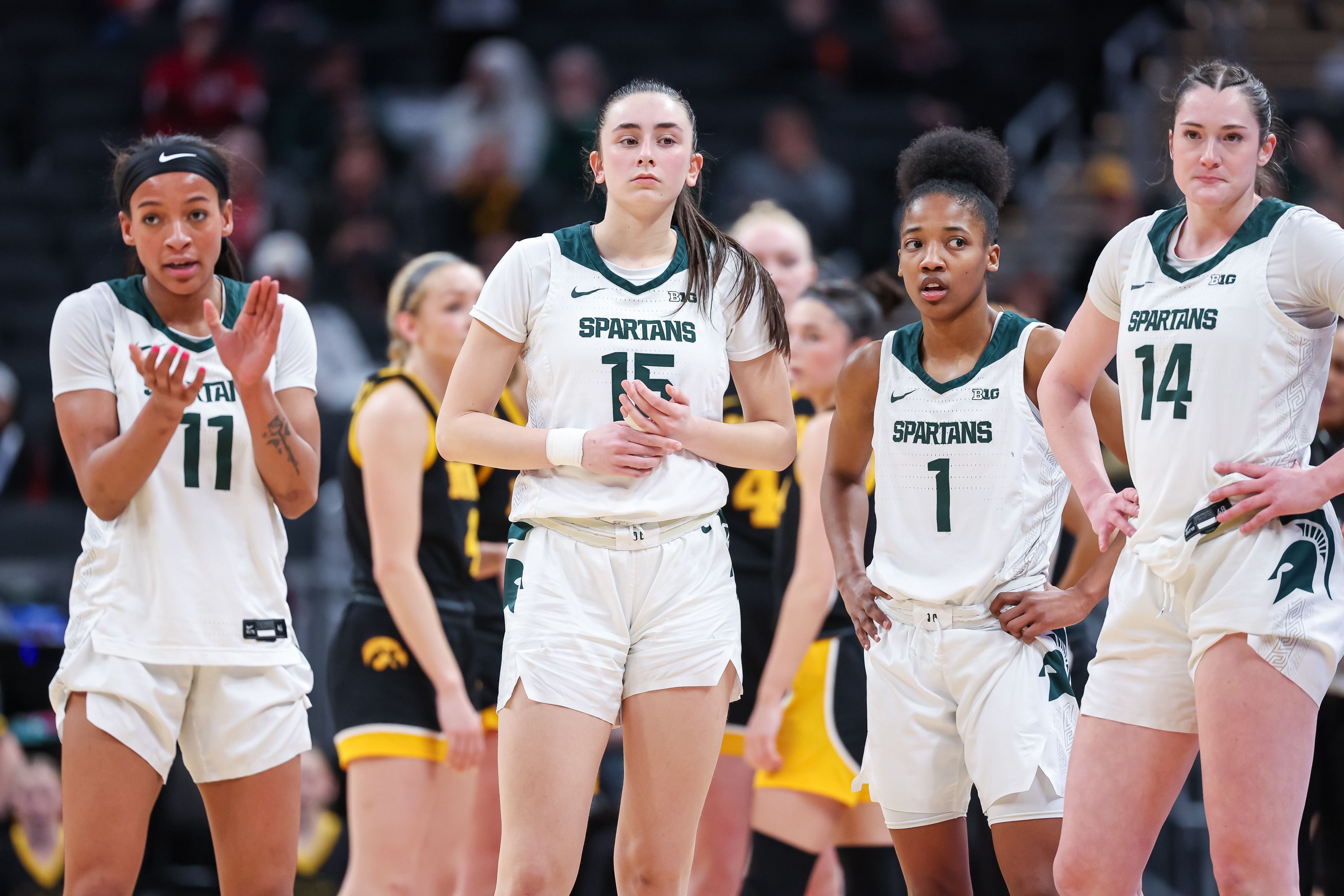 Photo of a group of basketball players gathered watching the court during a game.