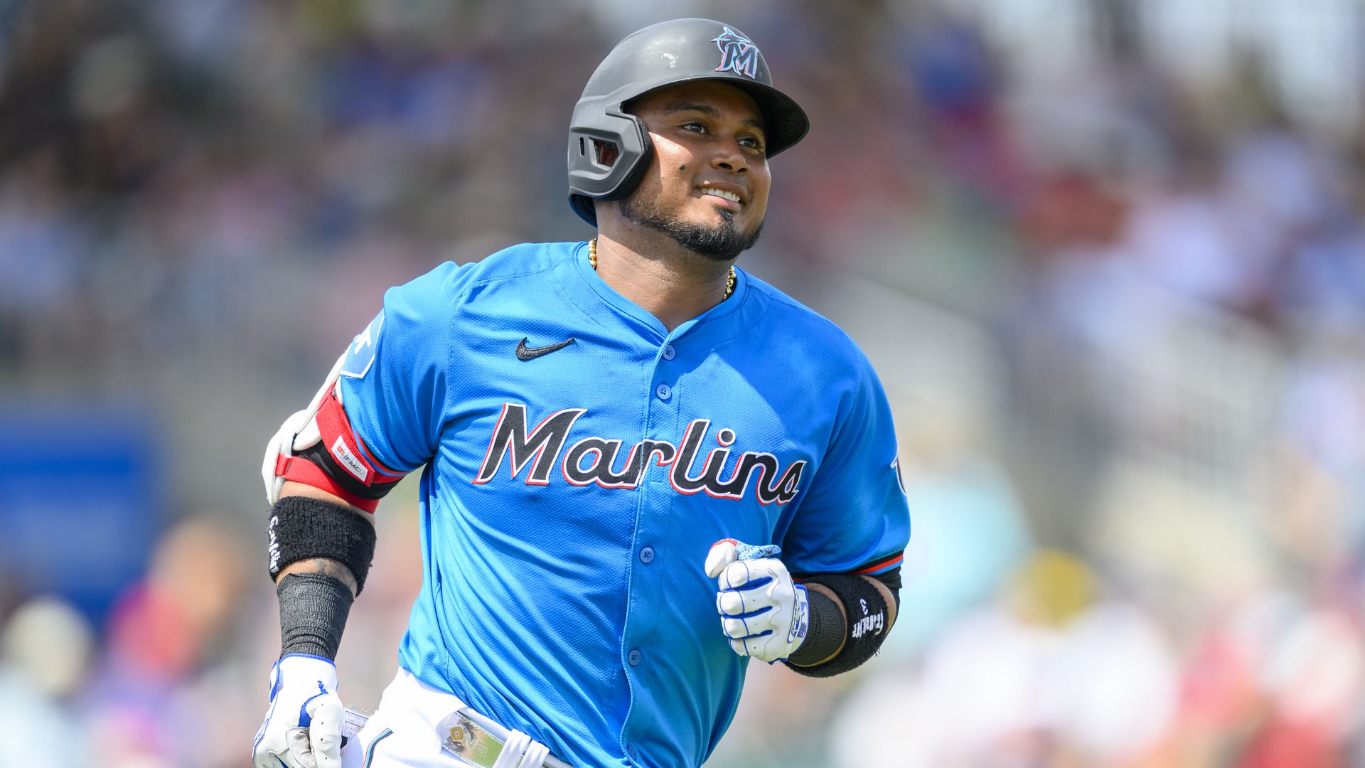 Miami Marlins infielder Luis Arraez  smiles as he runs to first base.