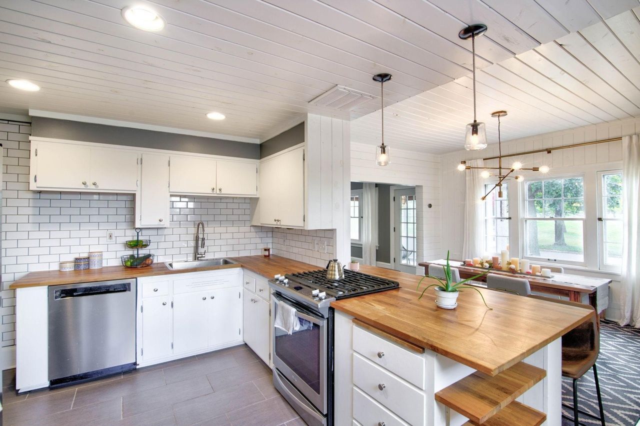 modern kitchen with butcher block counters and tile backsplash