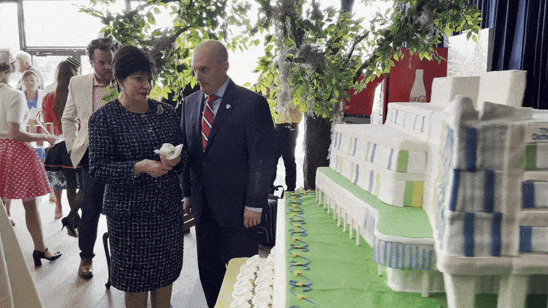 Gayle Benson and Pete November look at a cake version of the Ochsner Children's Hospital.