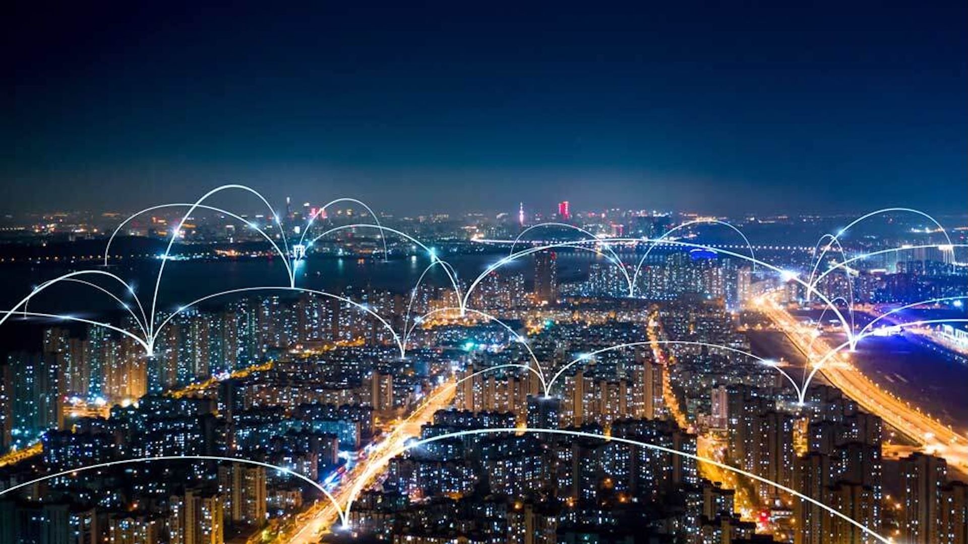 An aerial view of a city, with beams of light going from block to block.