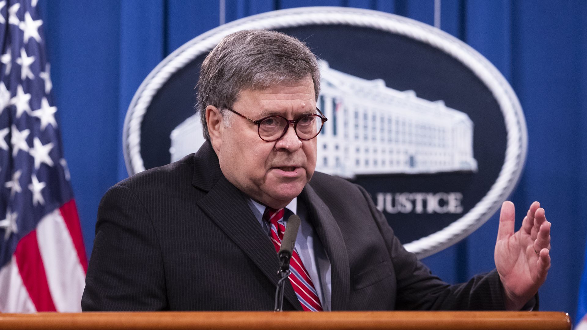 Picture of Bill Barr speaking behind a DOJ podium
