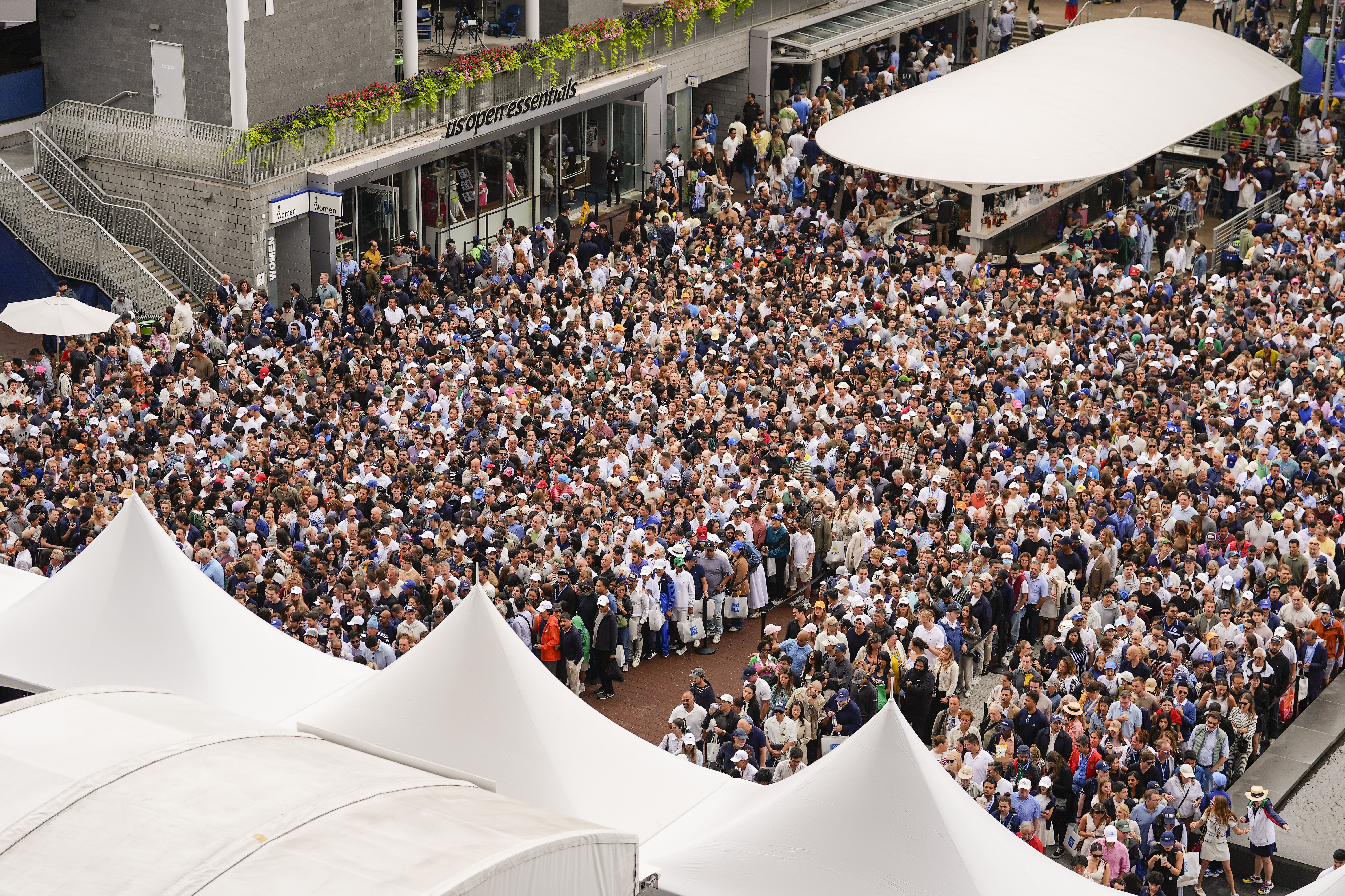 Tennis fans line up to get into Arthur Ashe Stadium to watch Carlos Alcaraz win the U.S. Open final over Jannick Sinner in New York yesterday.