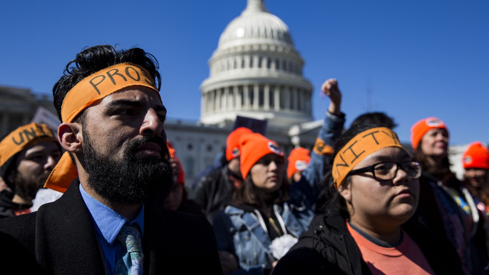 DACA protestors wearing orange headbands out front of the U.S. Capitol building