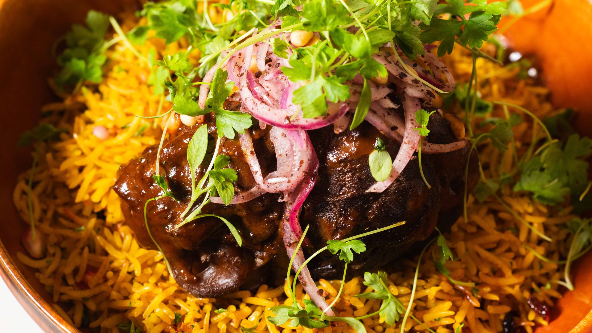 meat on top of orange rice pilaf 