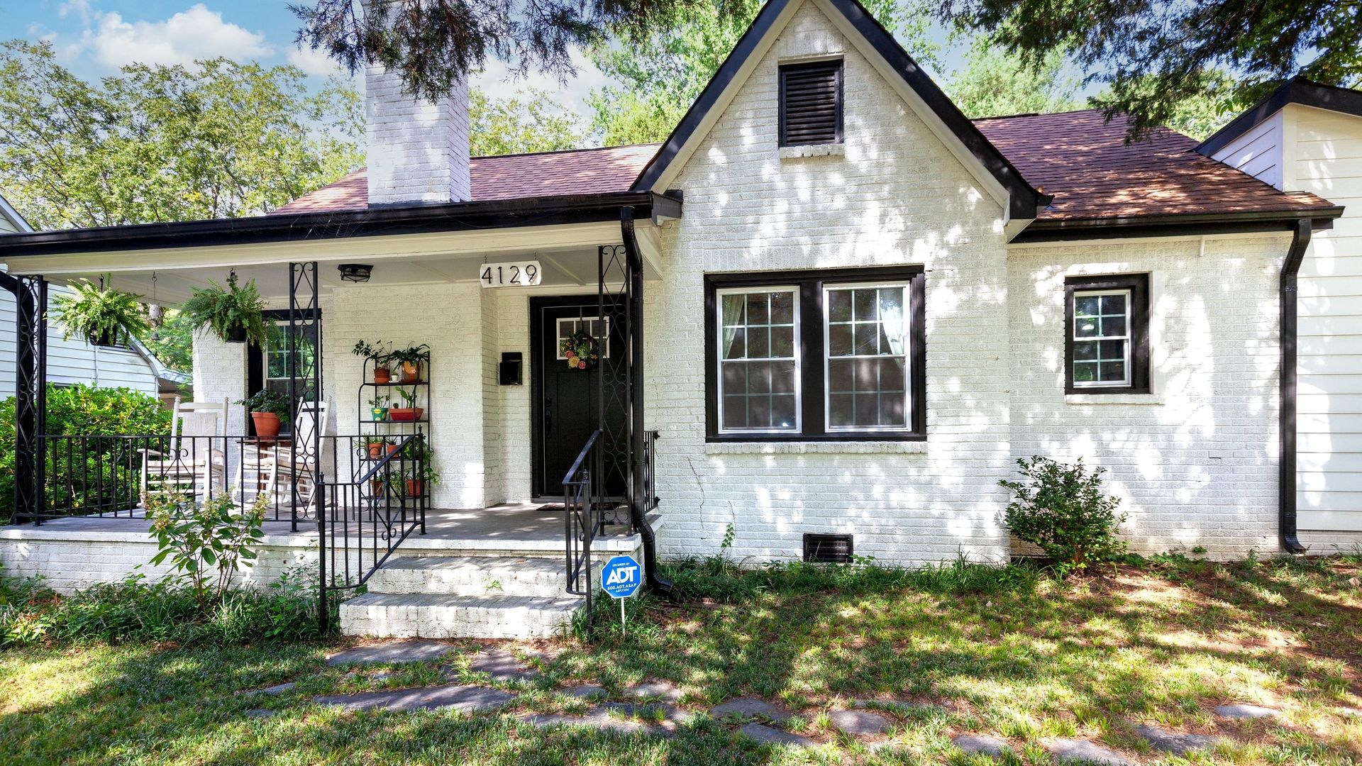 White brick home with a porch and chimney