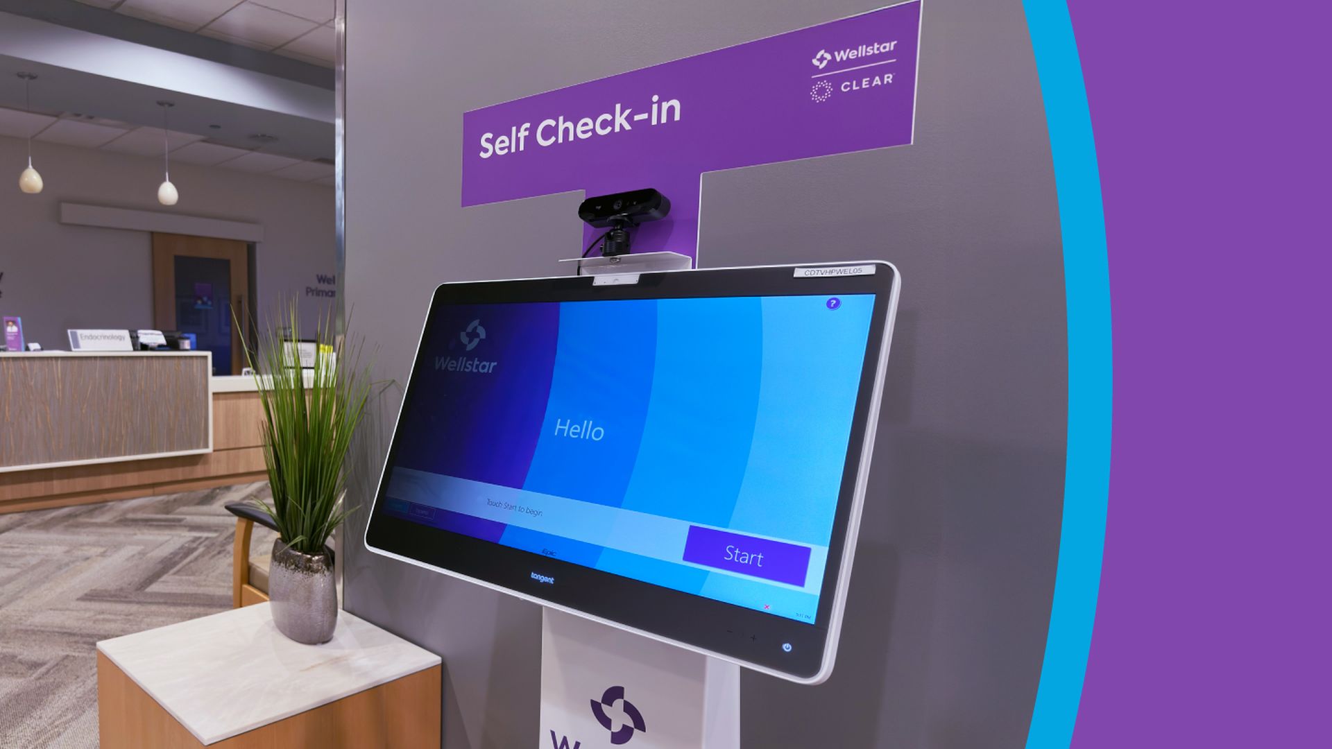 Purple self check-in kiosk with touchscreen displaying "Hello" and a Start button inside a modern medical office lobby with a plant on a small table nearby.