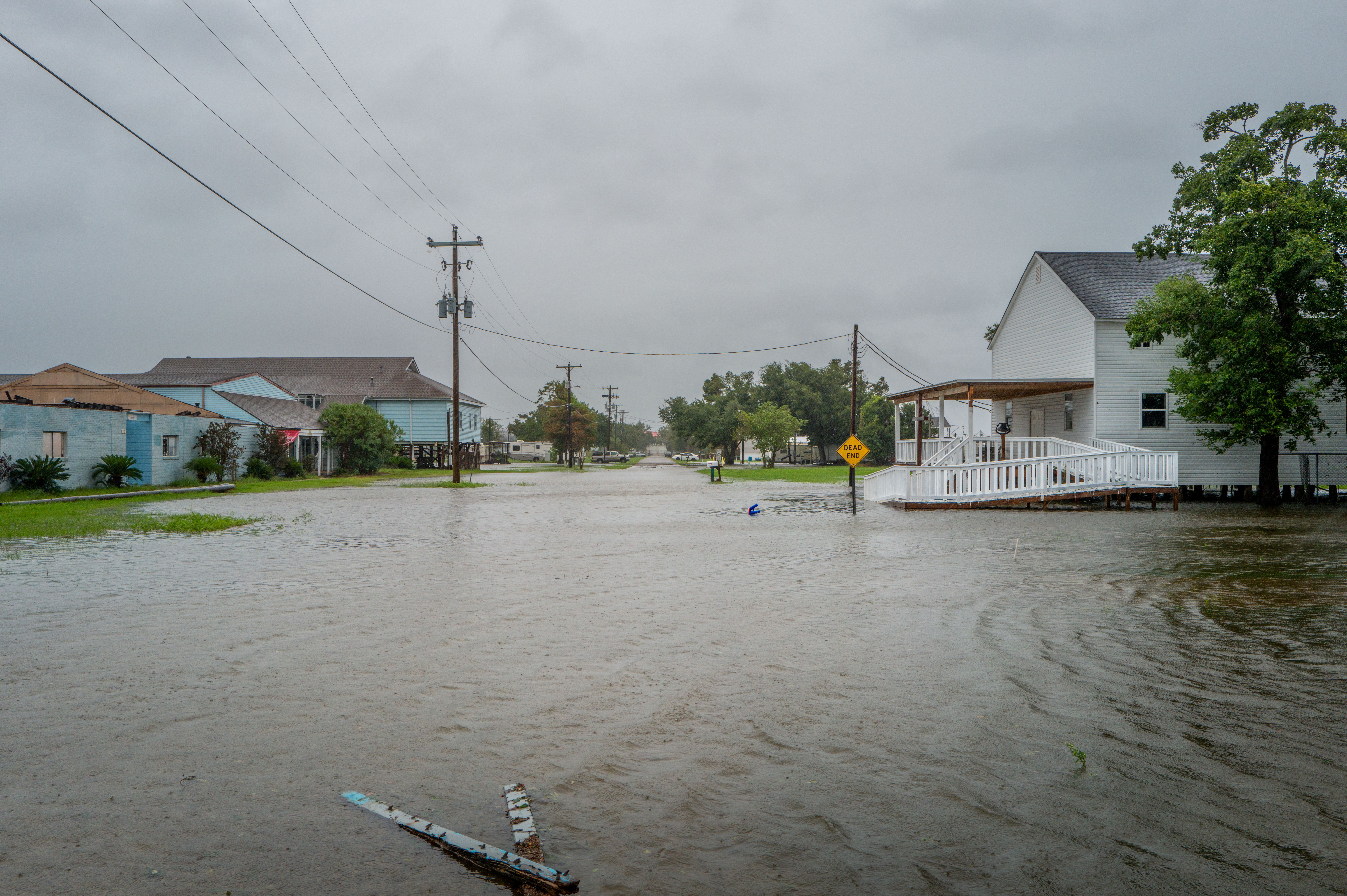 Rising floodwater inches up to a white building.