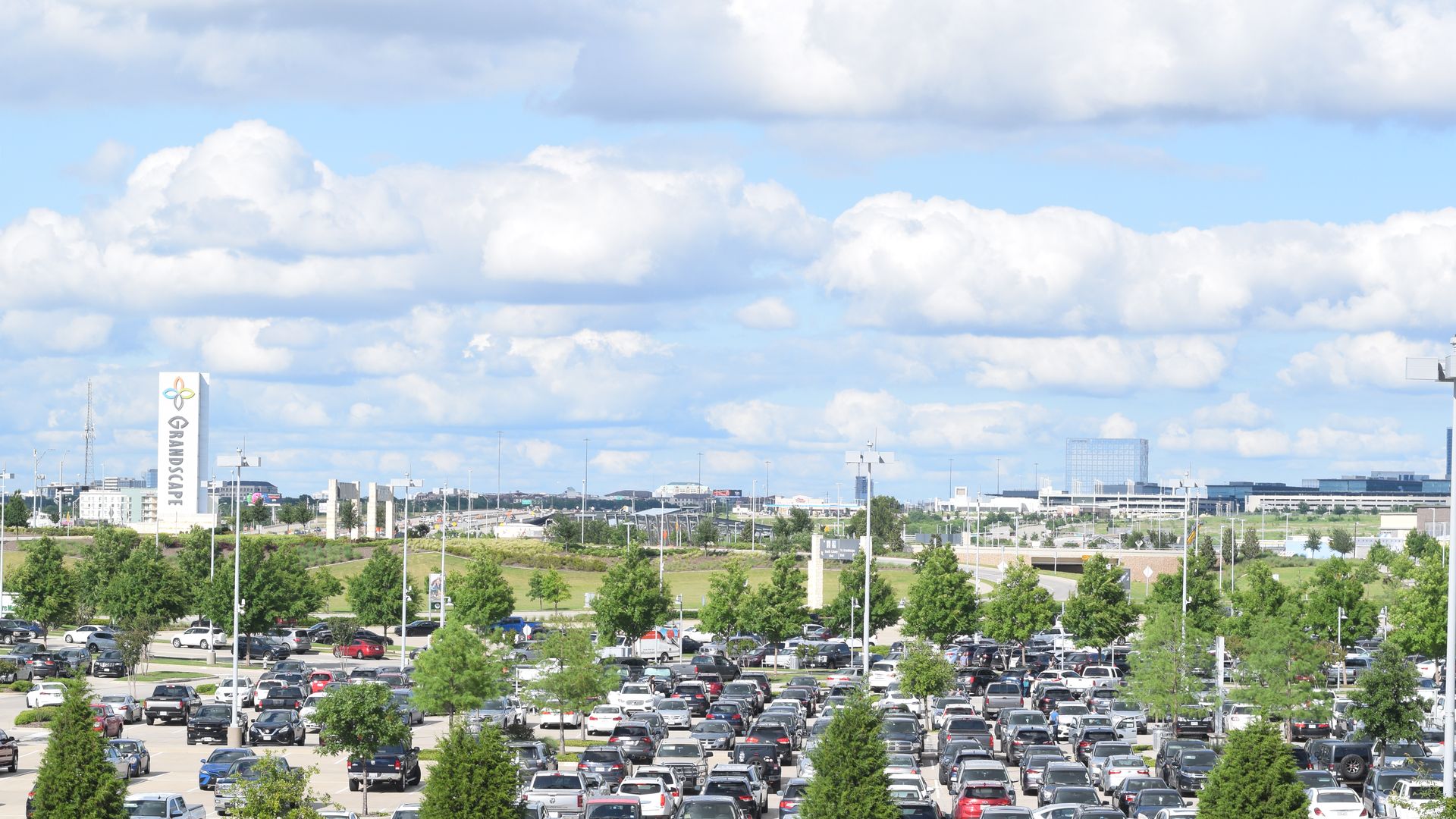 A parking lot with a sign that says "Grandscape" in the back