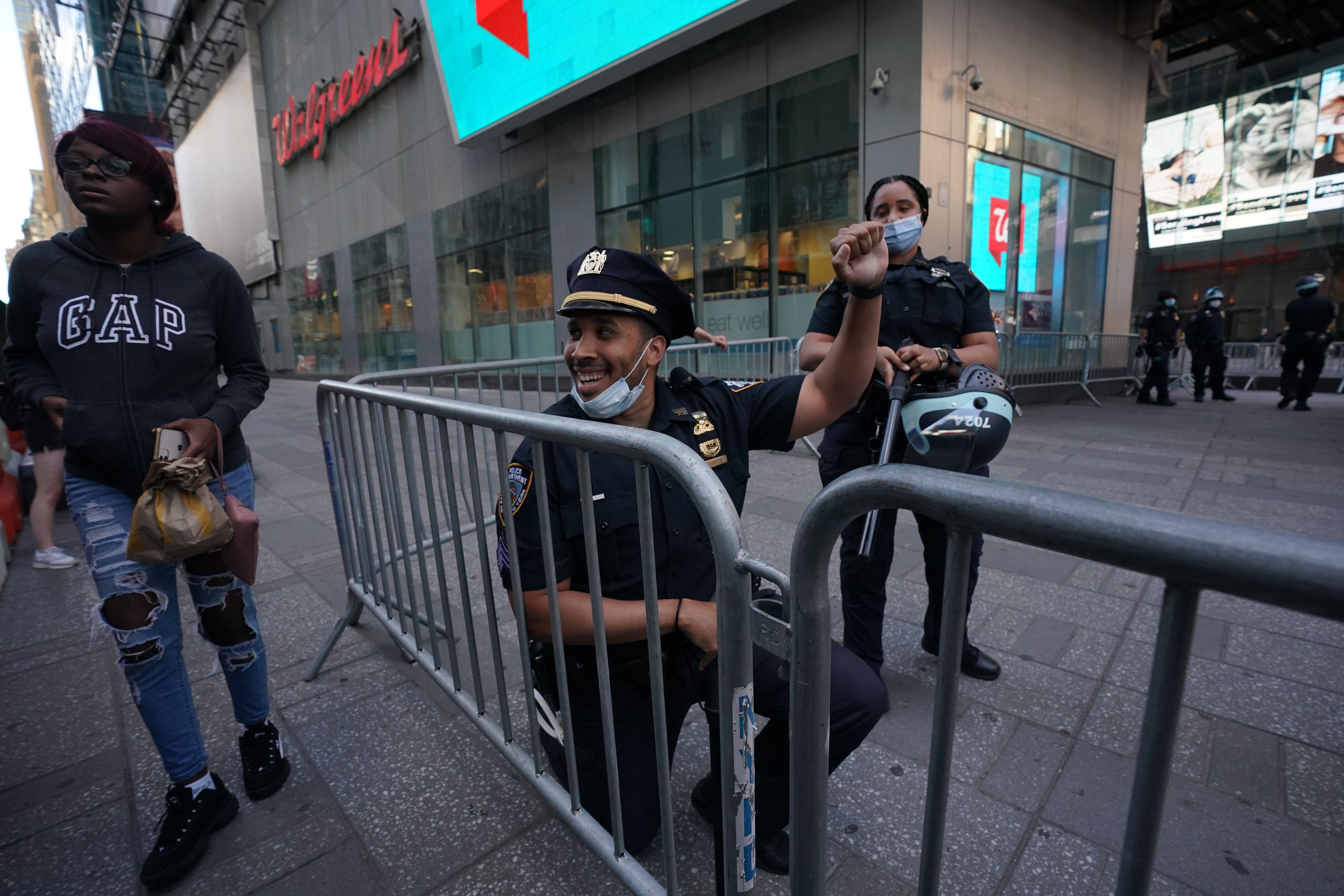 A ew York City police officer takes a knee during a demonstration by protesters in Times Square 