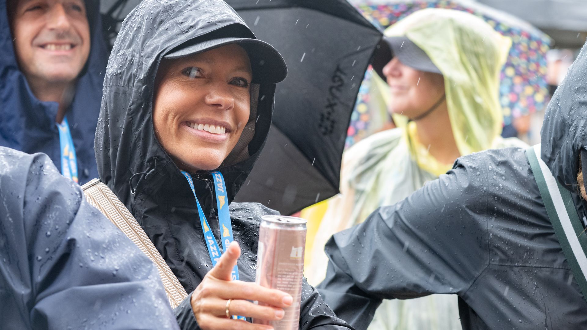 Image shows people smiling in rain ponchos.