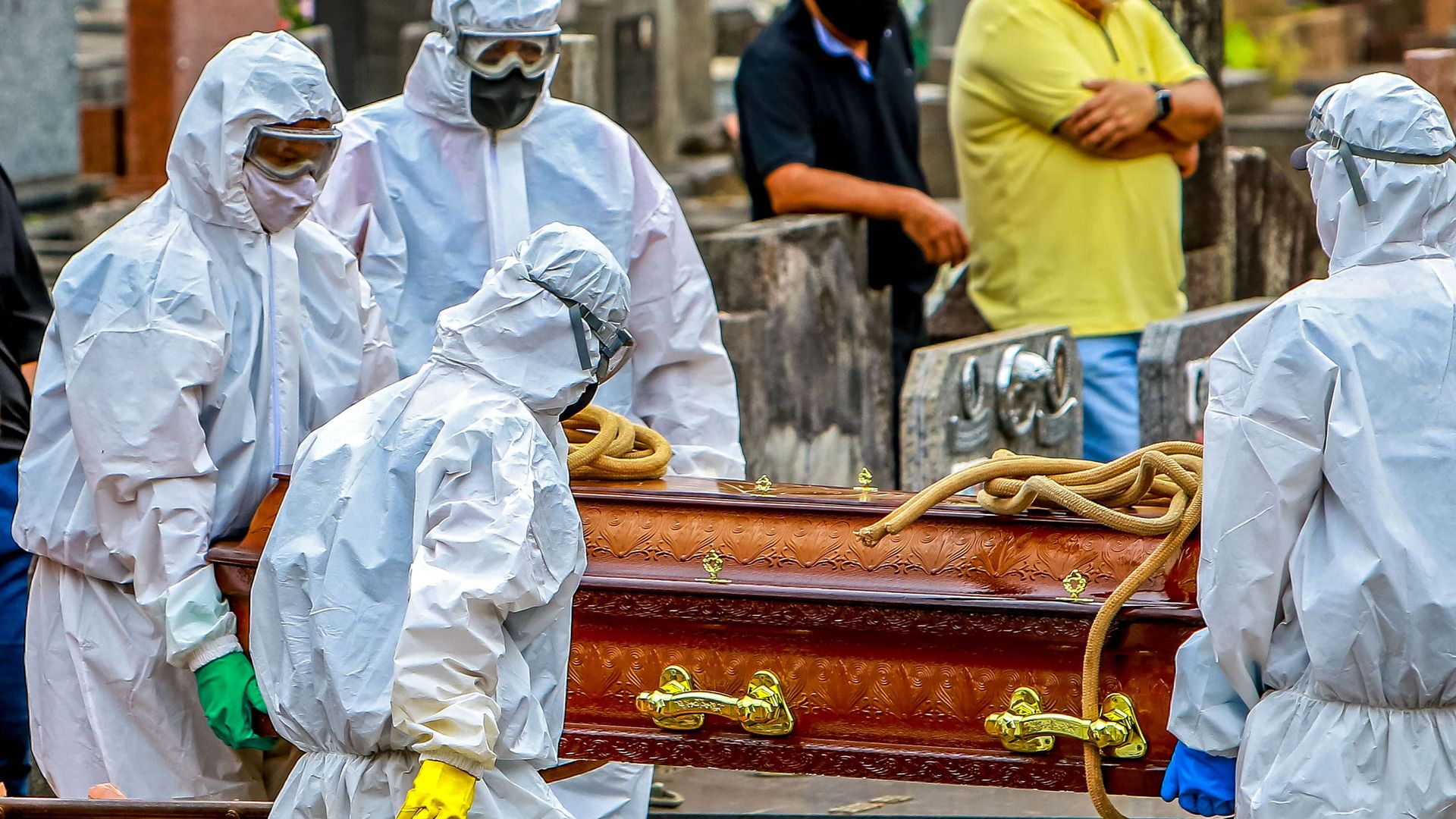 Cemetery workers carry a coffin during the burial of a victim of COVID-19 at the Sao Joao municipal cemetery in Porto Alegre, Brazil, on March 26, 2021