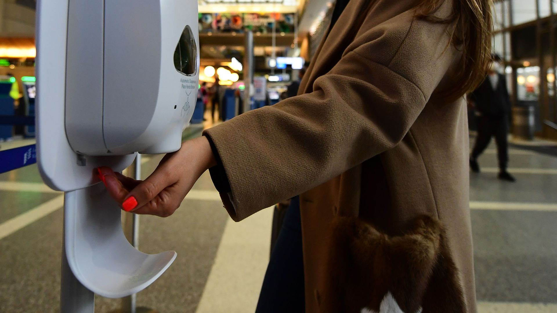 A woman uses hand sanitizer at Los Angeles International Airport