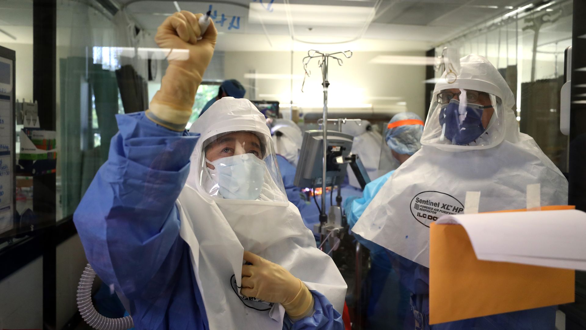 A nurse writes on a clear whiteboard