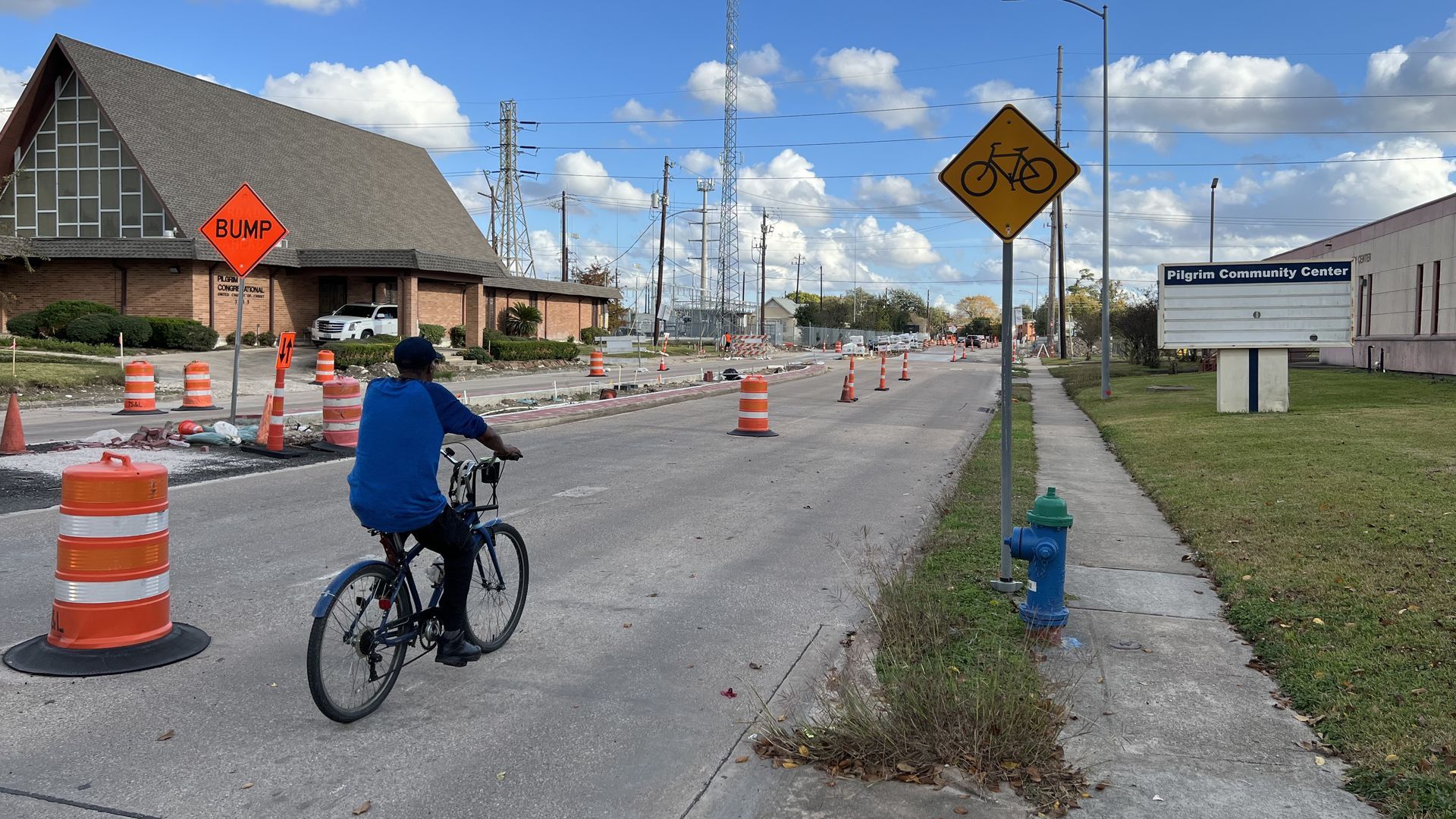A cyclist traverses along Blodgett Street as construction cones dot the street 