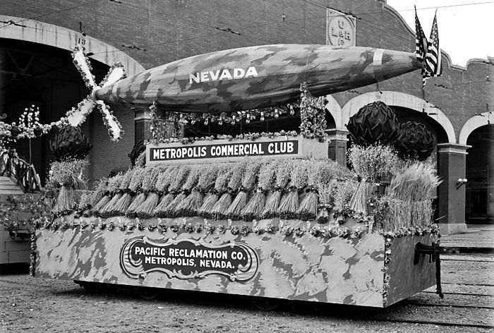A 1912 parade float shows a torpedo sailing over bails of wheat.
