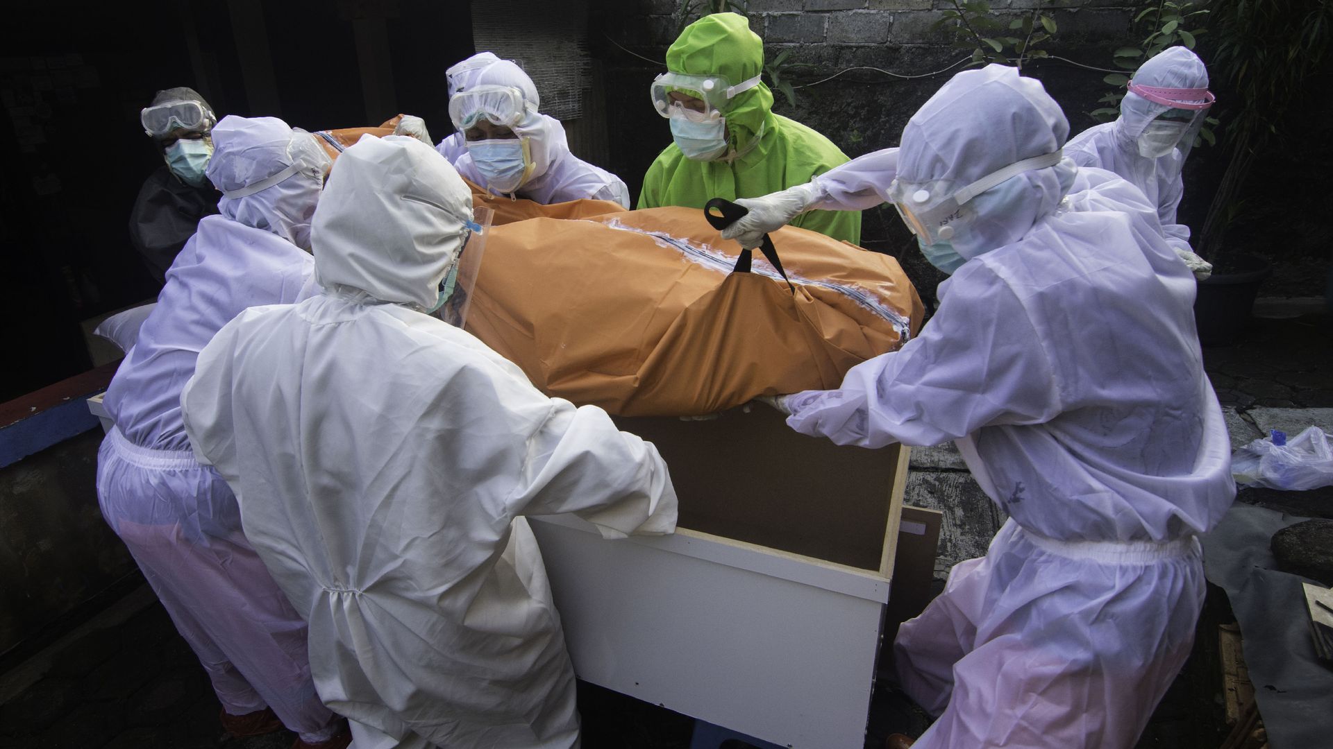 Picture of Indian workers carrying a body in a bag