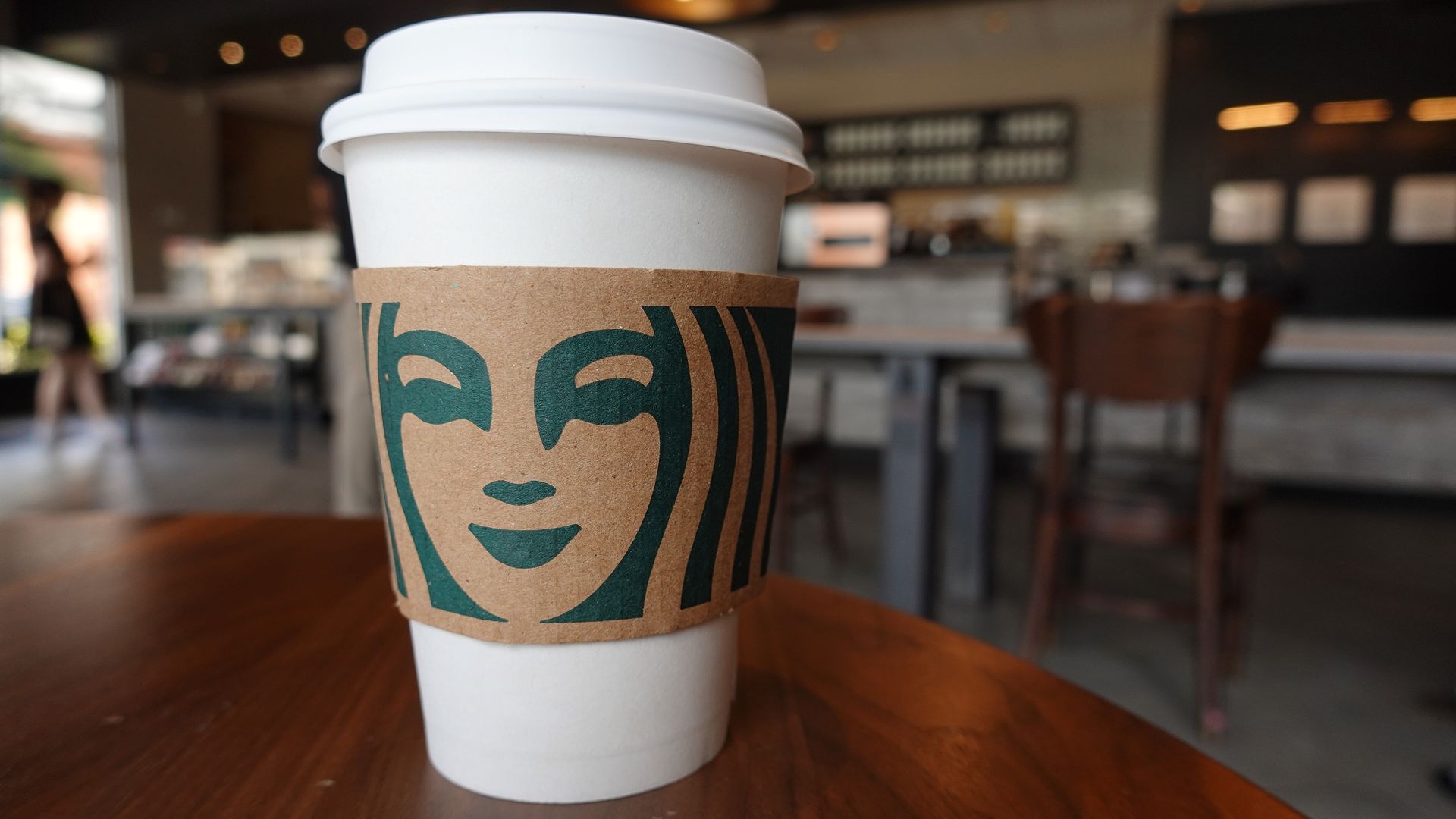 A Starbucks coffee cup sits on a table