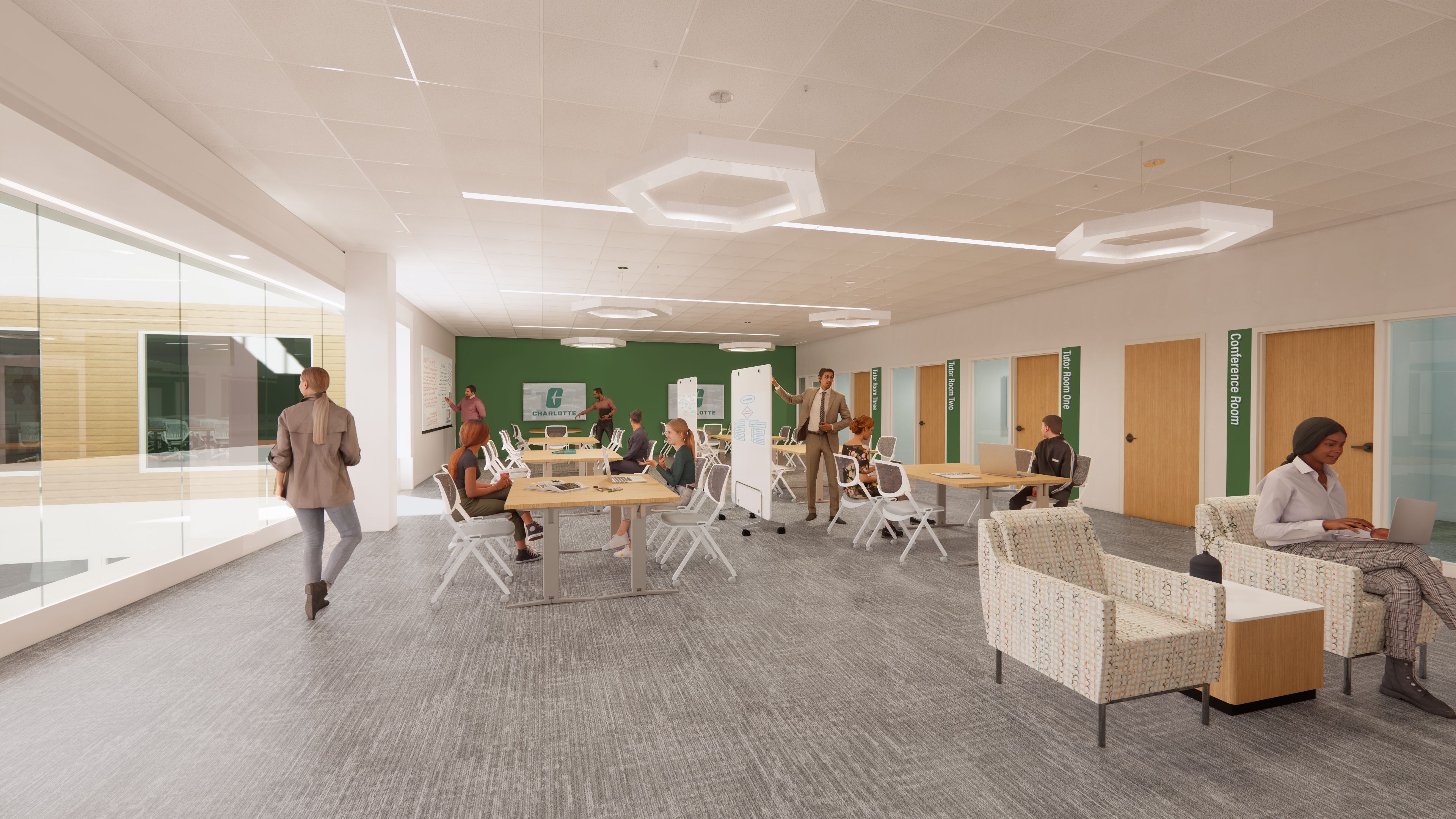 Modern office with gray carpet, white ceiling, green accent wall, multiple wooden tables, and people working or discussing. Doors labeled Tutor Rooms and Conference Room.