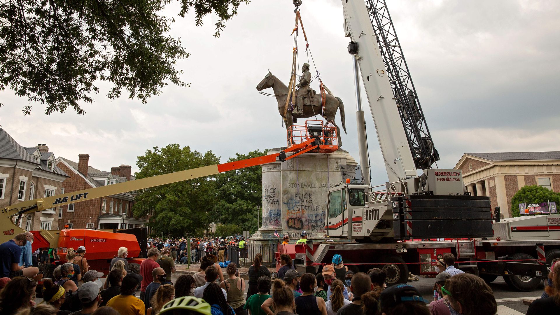 People watch as the Stonewall Jackson statue is removed from Monument Avenue in Richmond, Virginia on July 1, 2020. - Workers in Richmond, Virginia, removed a statue of Thomas "Stonewall" Jackson, a Confederate general, after the city's mayor ordered the "immediate removal" of Confederate monuments.